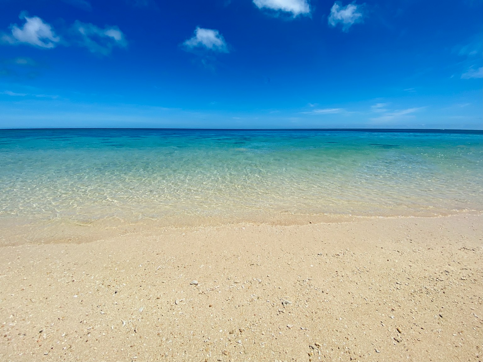 Pemandangan laut biru dan pantai pasir putih langit cerah dan ombak lembut
