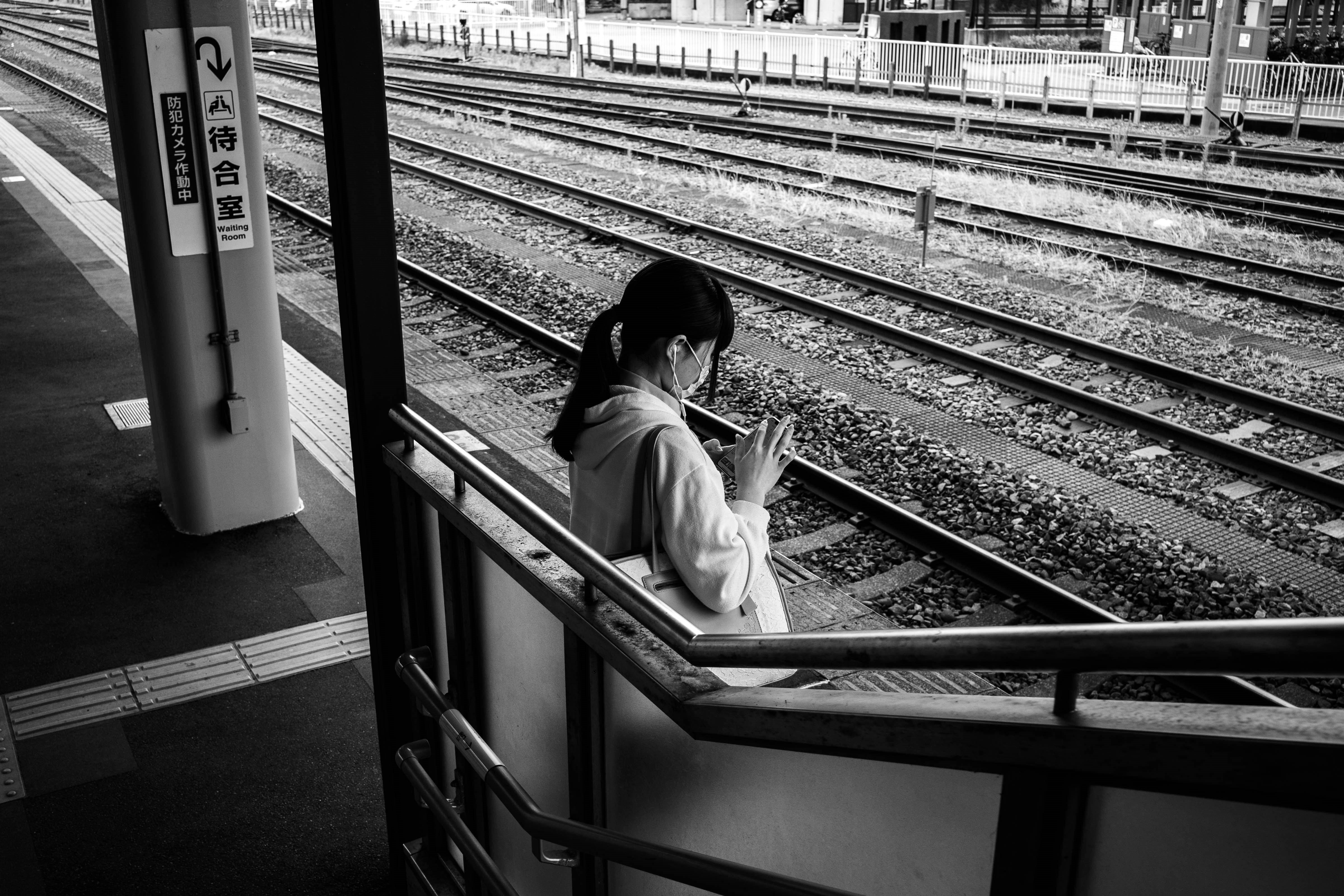 persona seduta su una panchina del marciapiede ferroviario