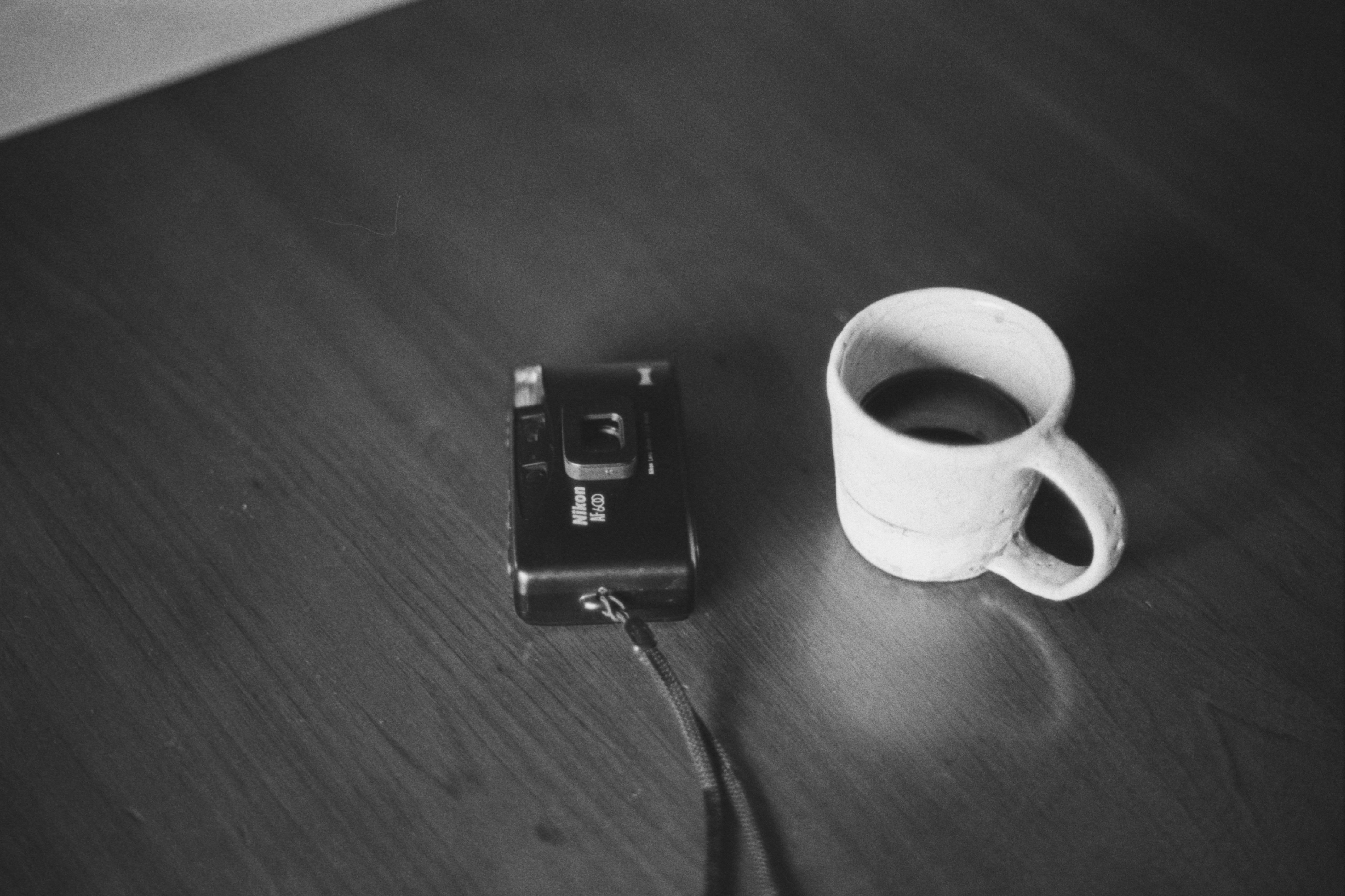 weiße Tasse und kleines Gerät auf dunklem Boden