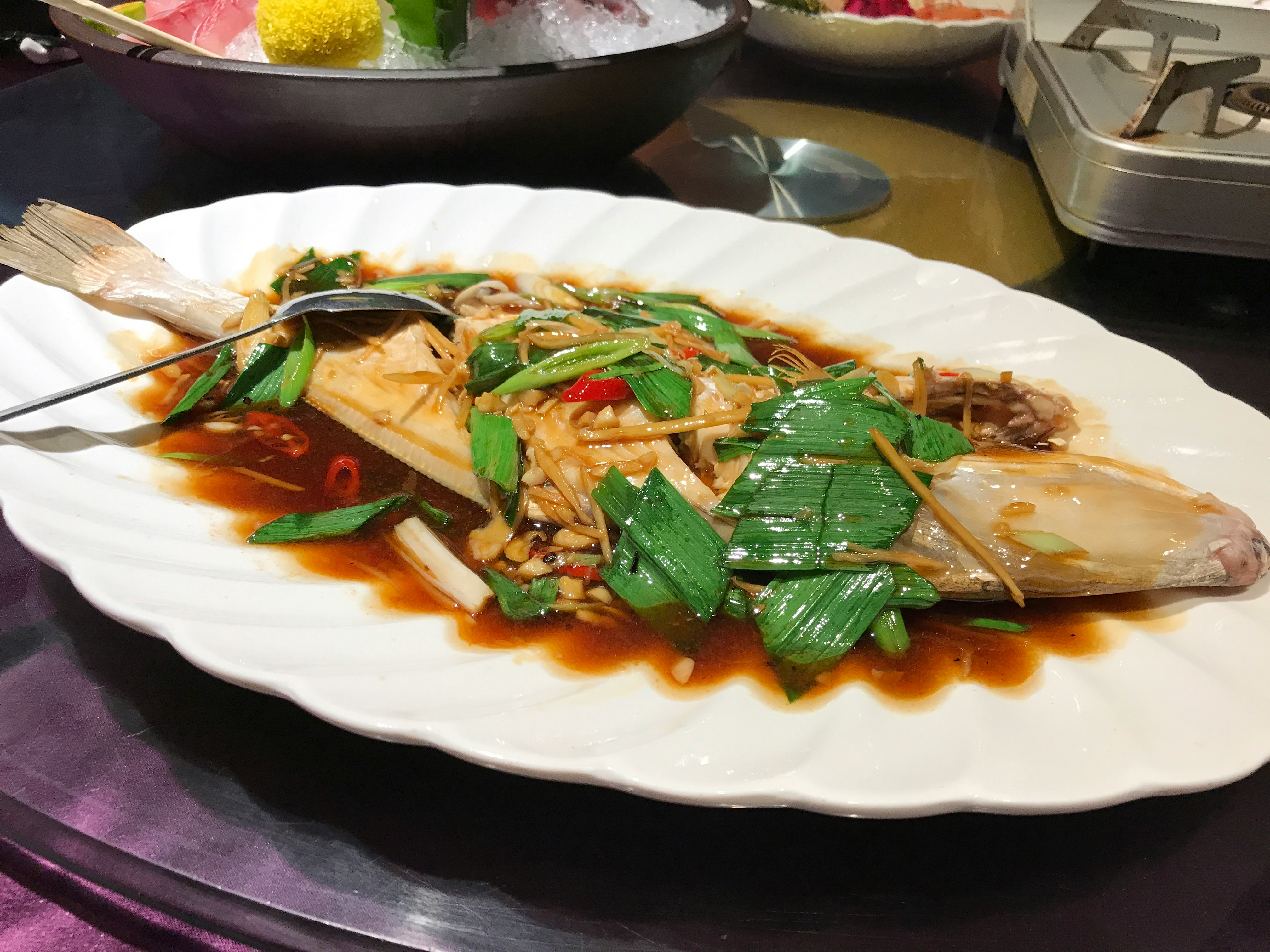 白盤上的鮑魚燉煮配青菜