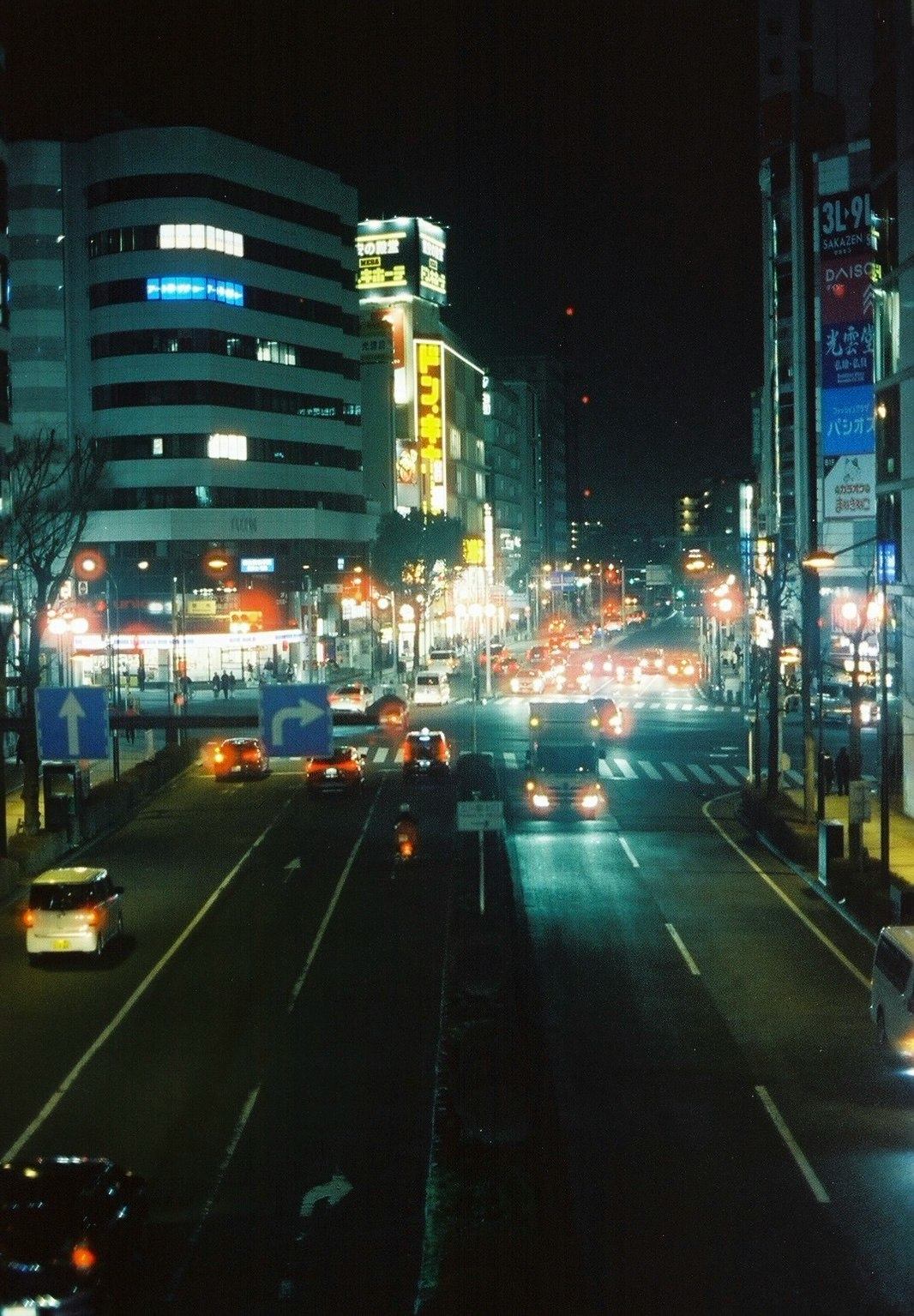 Night cityscape with bright street lights and vehicles