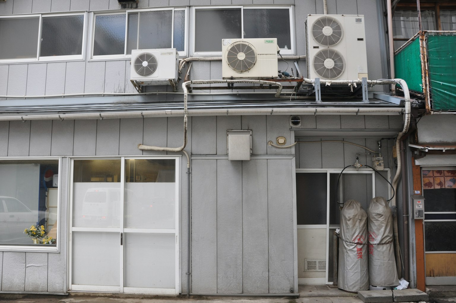 Esterno di un edificio grigio con più unità di aria condizionata