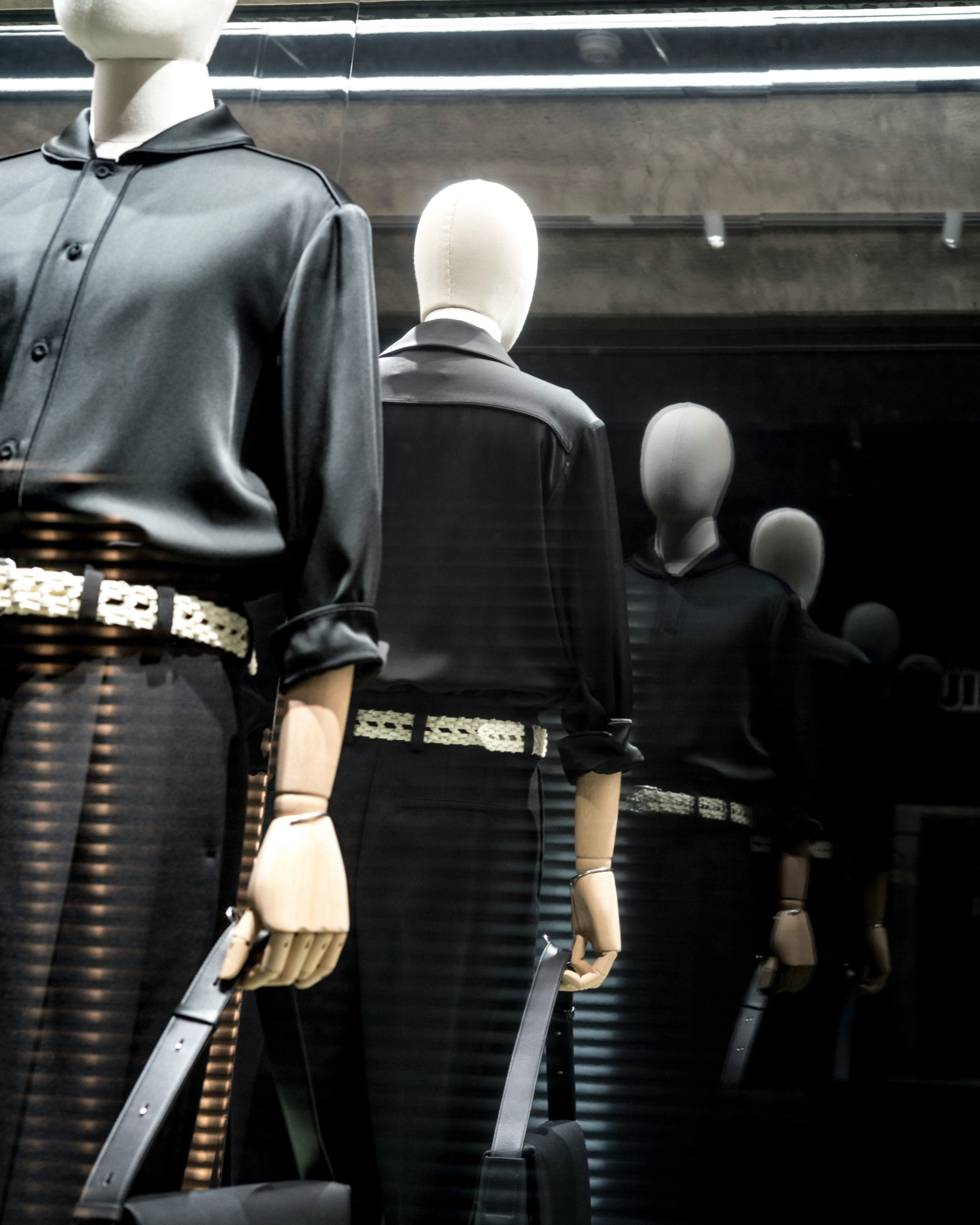 mannequins in suits lined up in a shop window