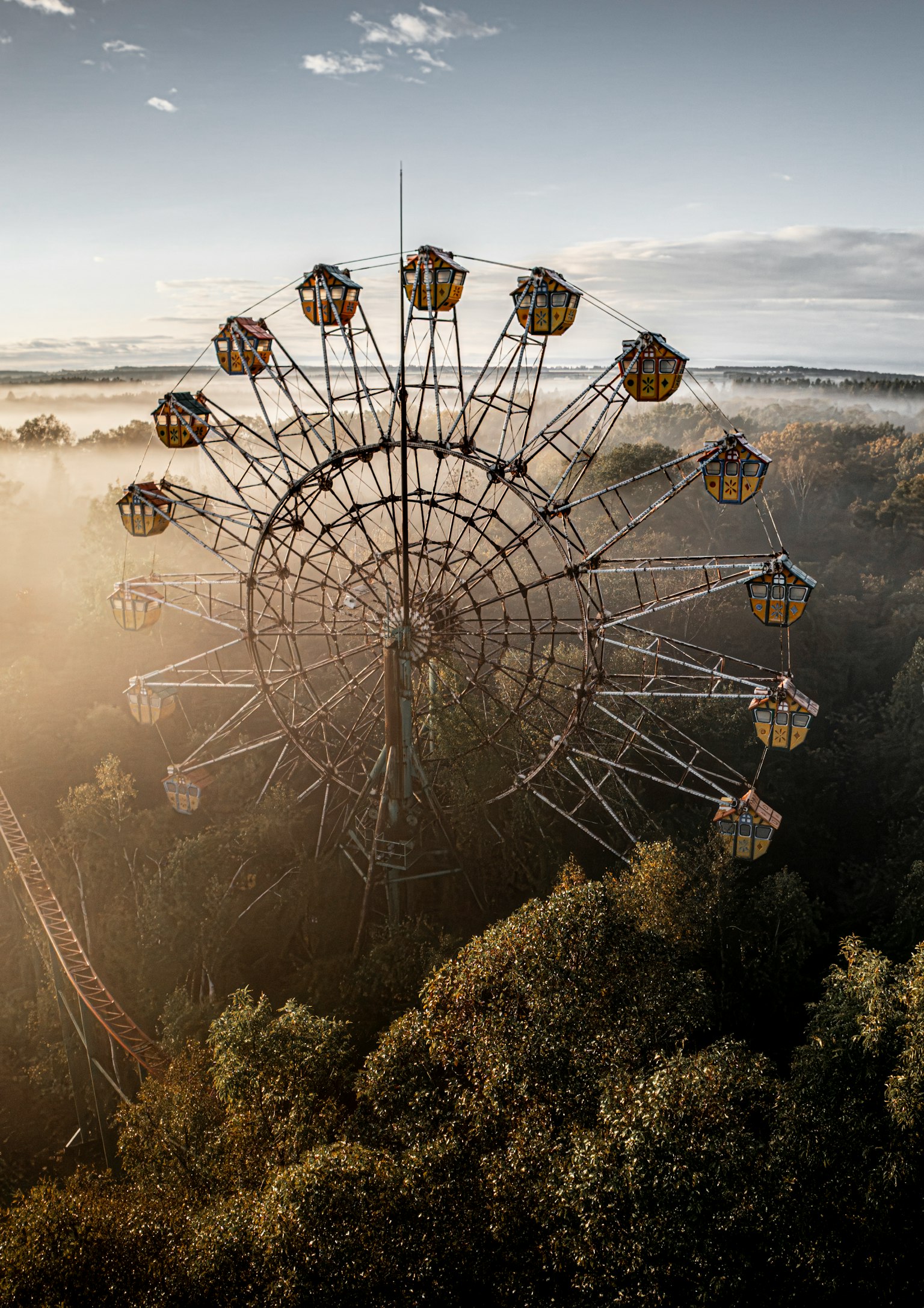 霧に包まれた森の中にある観覧車の上からの眺め