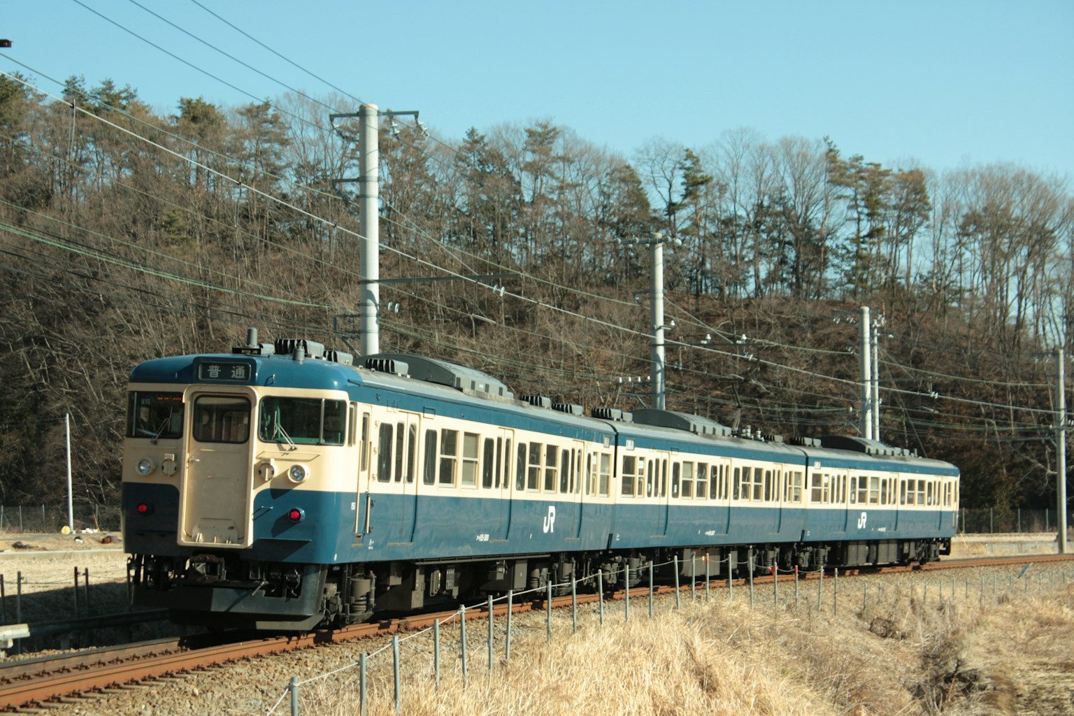 Blue train traveling along the tracks