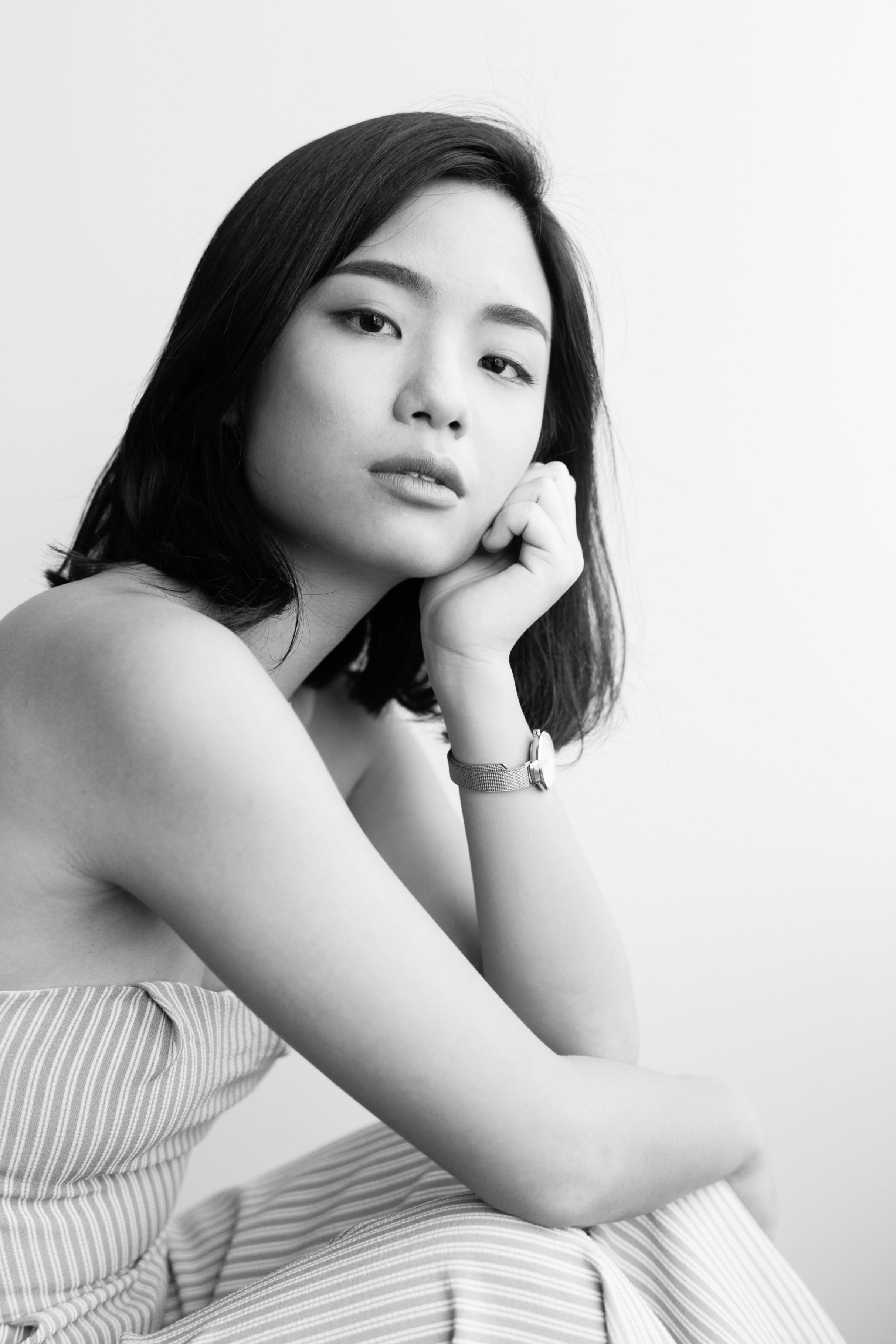 モノクロの室内で頬杖をつく女性のポートレート