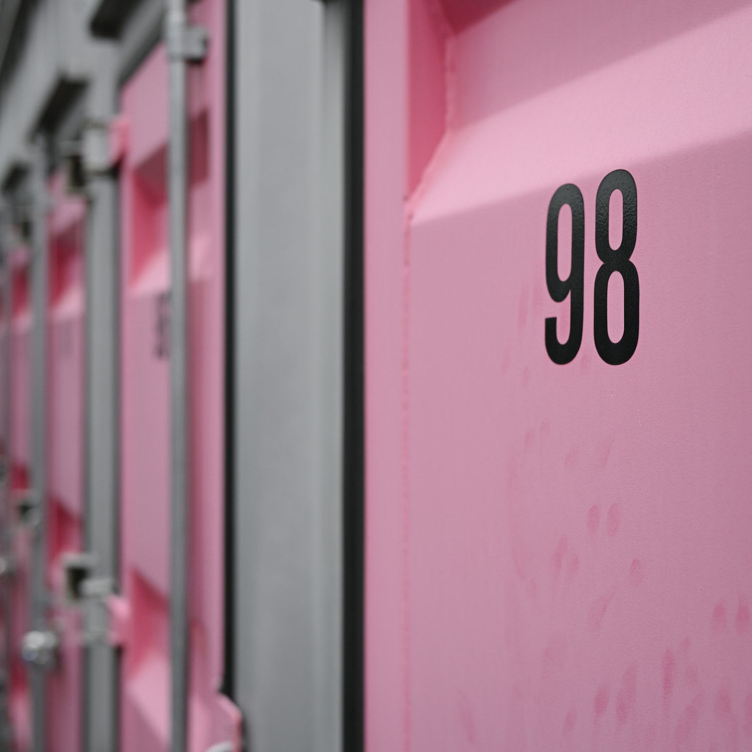 Close-up nomor 98 pada kontainer pink