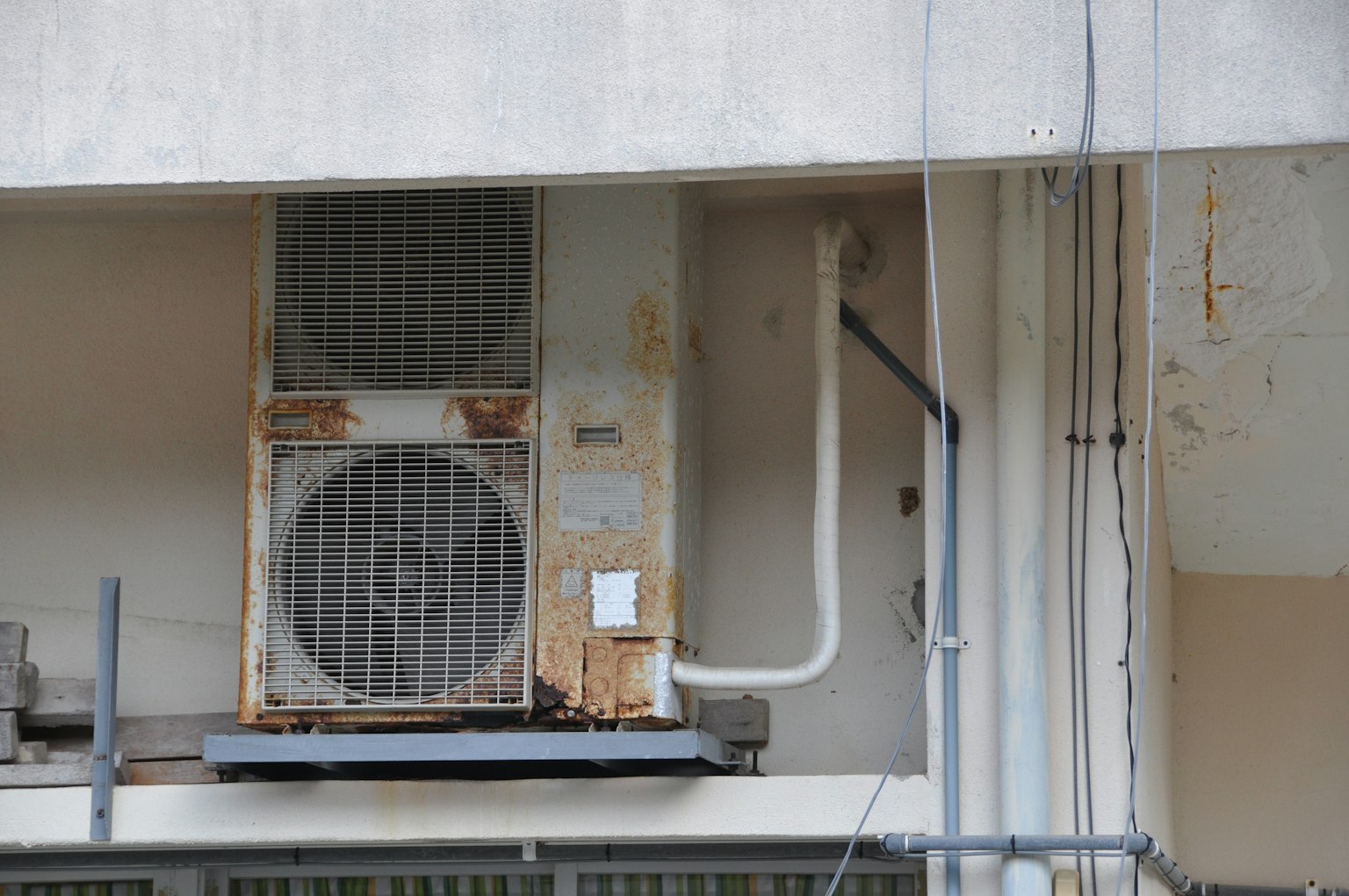 Old air conditioning unit mounted on the exterior wall of a building