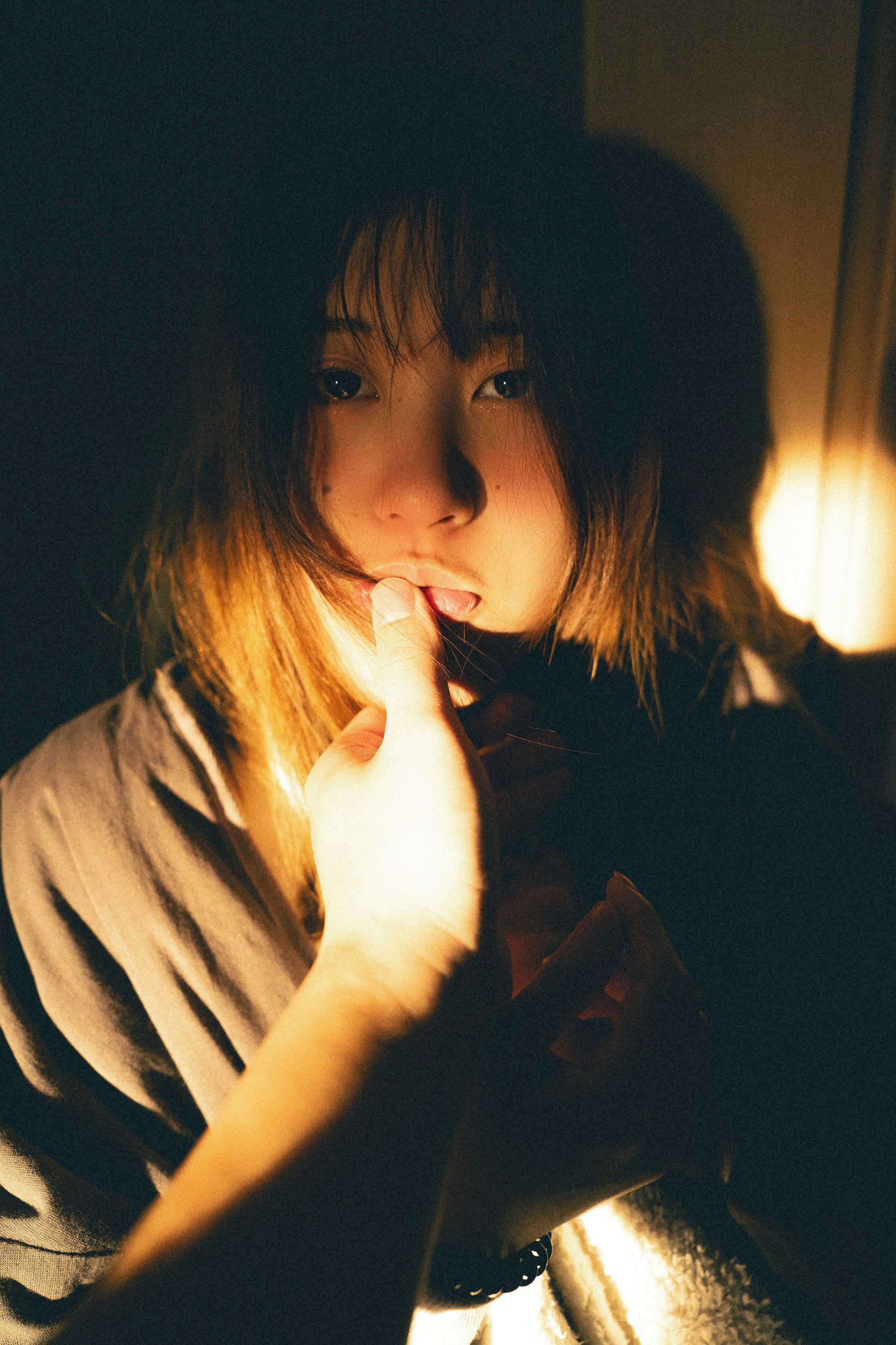 Indoor image of a wife making a cute, clingy gesture with her finger near her mouth