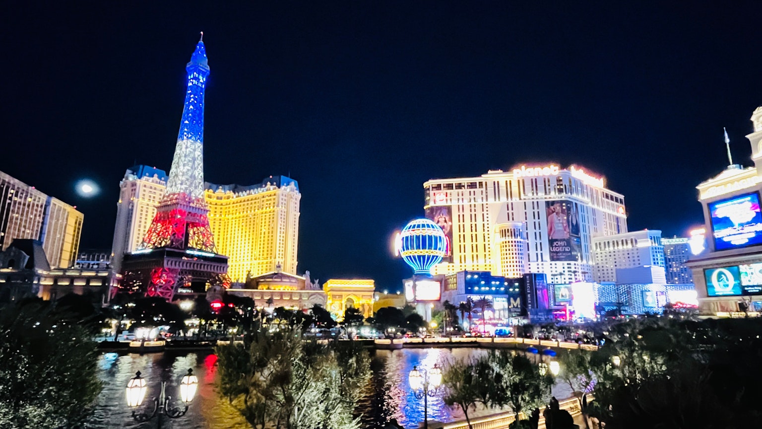 拉斯维加斯的夜景，照亮的建筑和水面反射，具有类似埃菲尔铁塔的结构