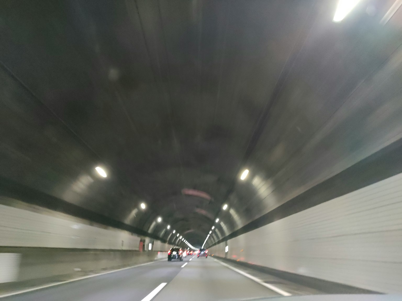 圖像顯示了高速公路隧道的視角，明亮的燈光和平滑的牆面