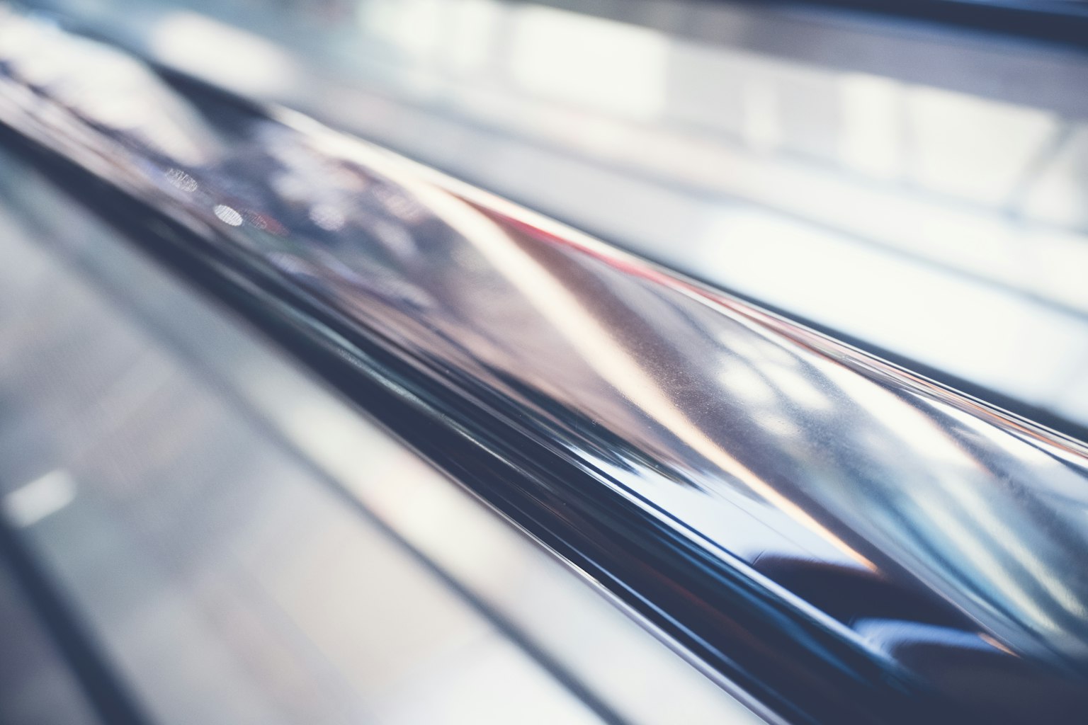 Gros plan sur une main courante métallique lisse d'un escalator