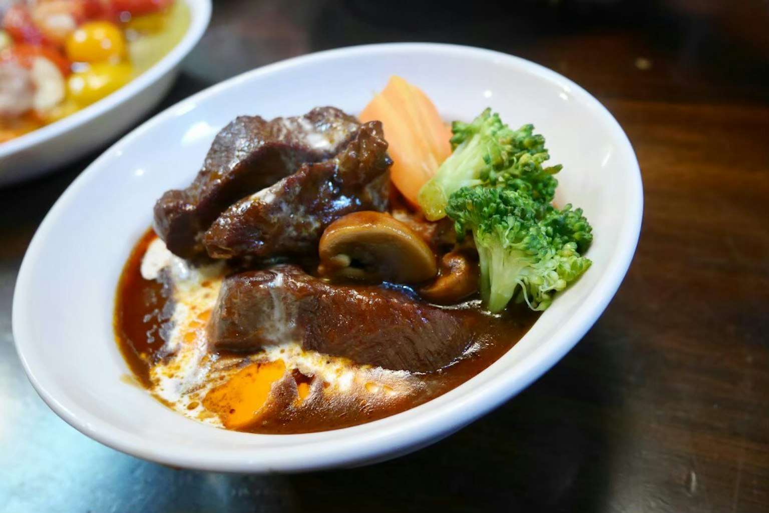 Semur daging sapi yang lezat disajikan dengan brokoli dan wortel