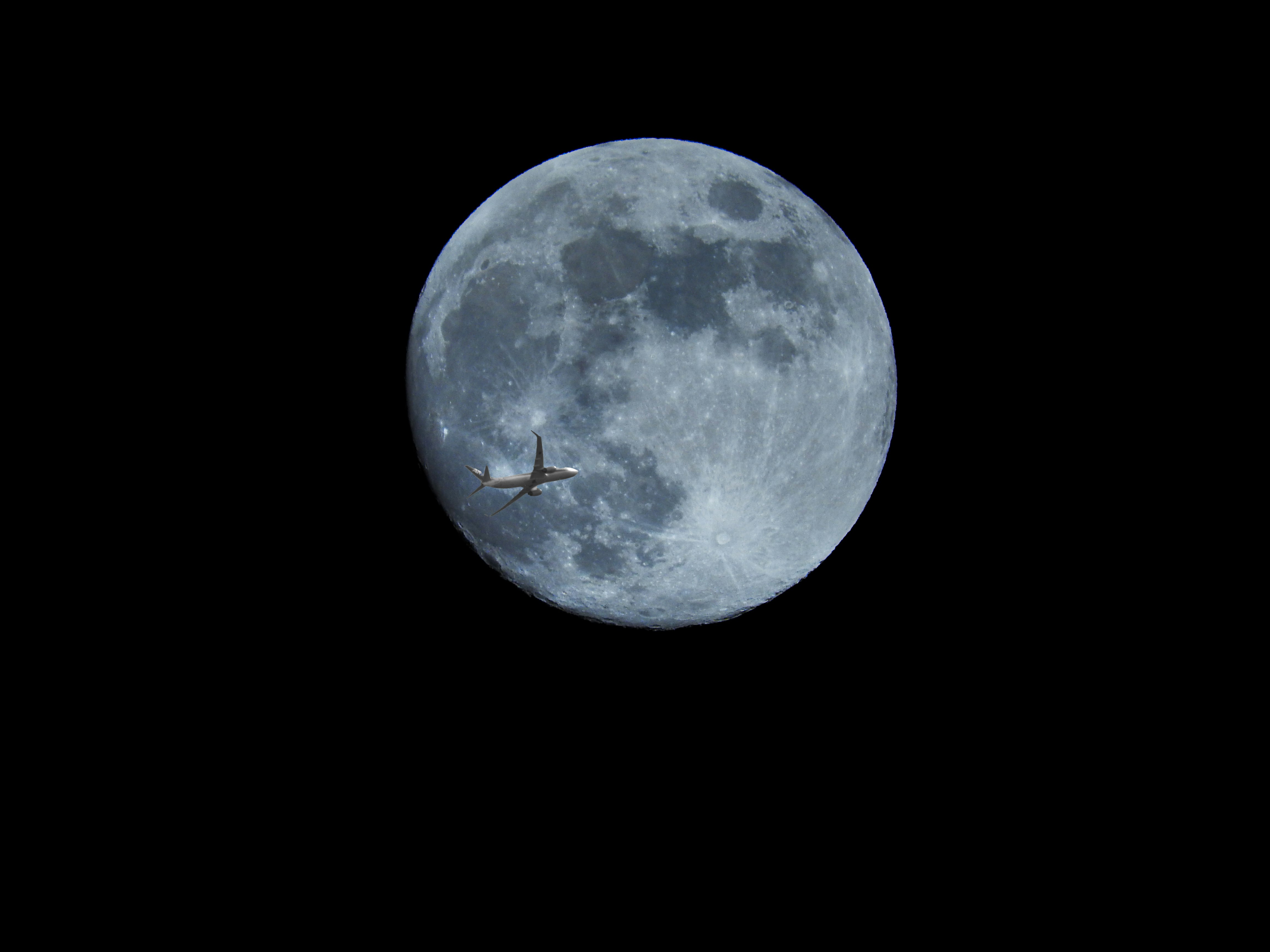 月と飛行機が飛ぶ夜空