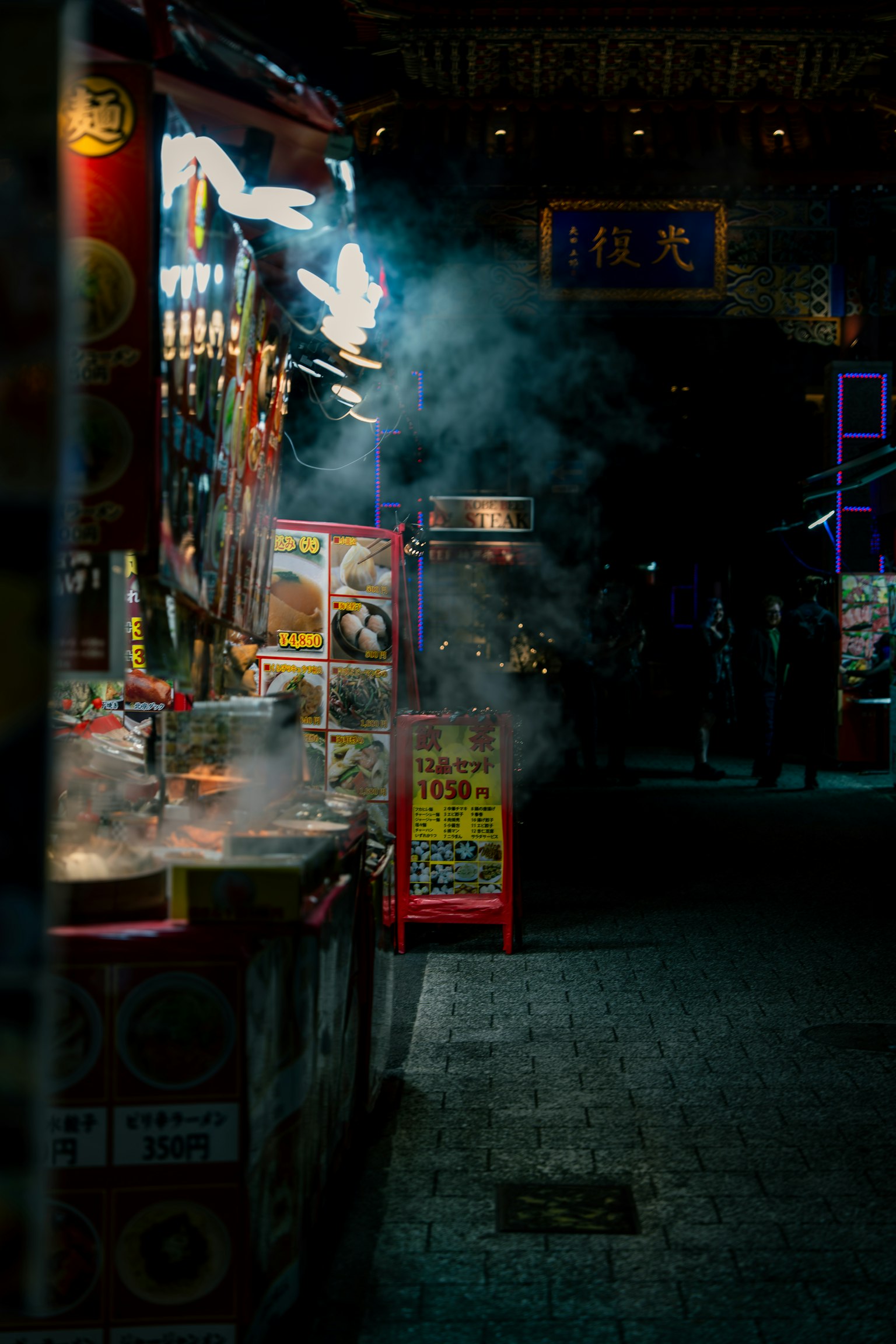 Đường chợ đêm với quầy thực phẩm và khói