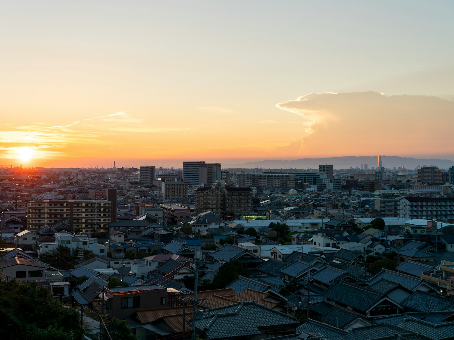 Stadtansicht bei Sonnenuntergang mit Dächern und Skyline