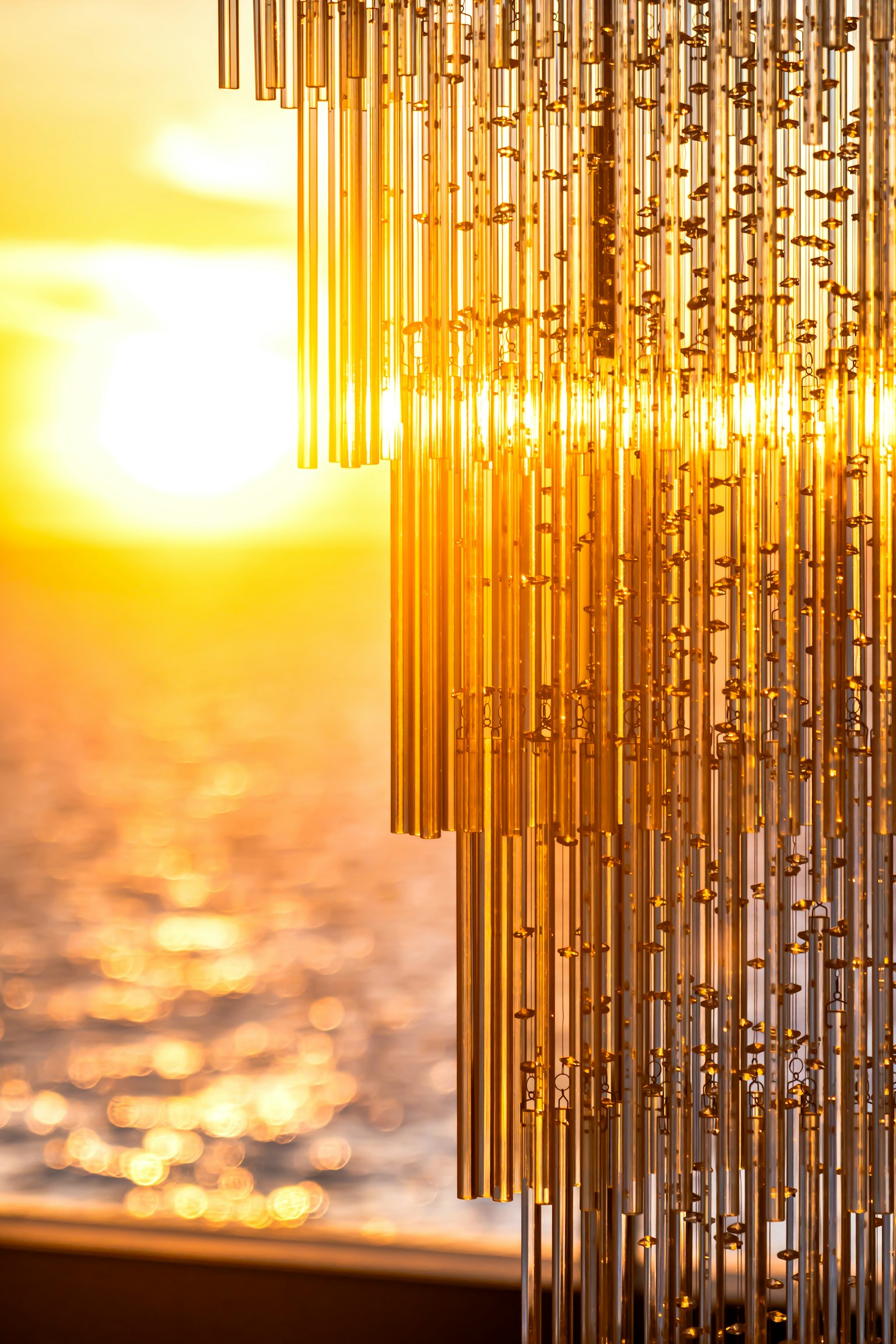 Detailed view of a beautiful crystal chandelier with sunset in the background