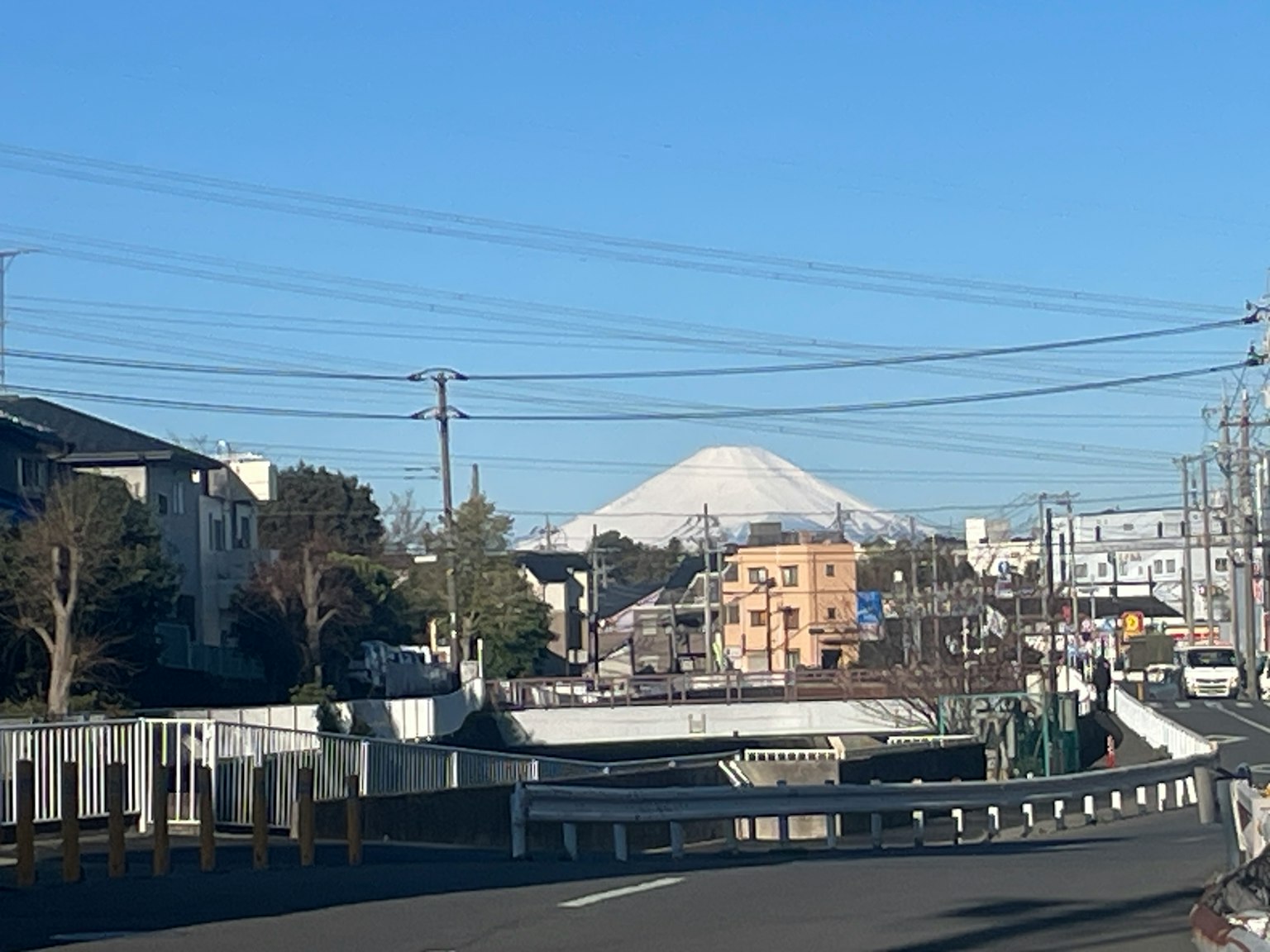 Cityscape with snow-capped Mount Fuji under a clear blue sky