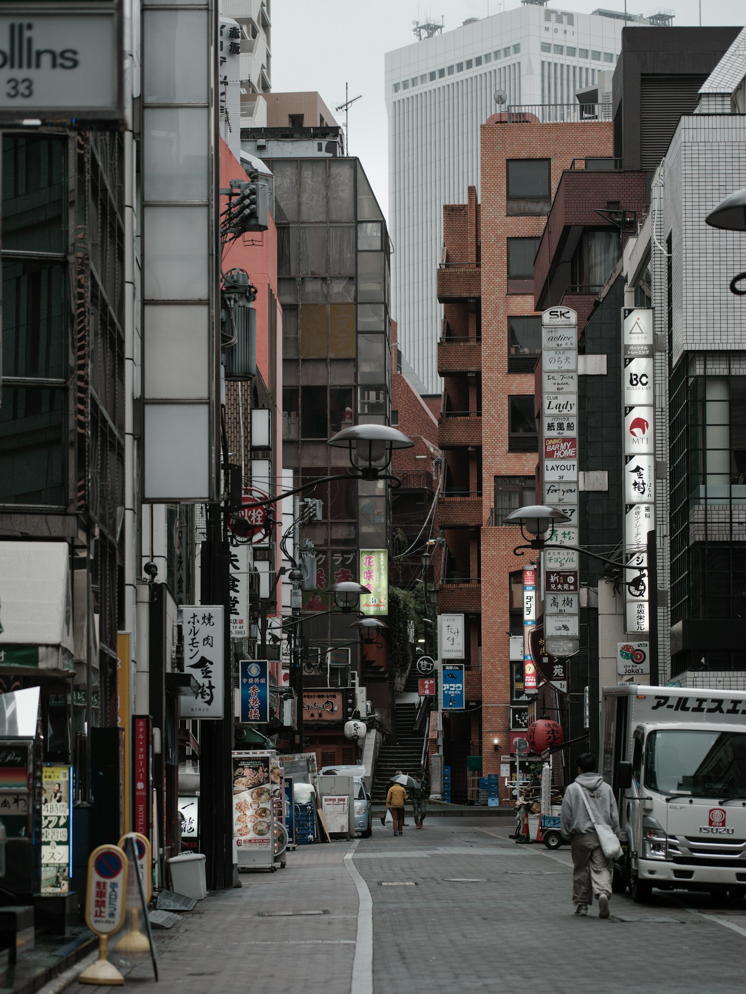 ทิวทัศน์เมืองที่มีอาคารและป้ายตามตรอกแคบๆ