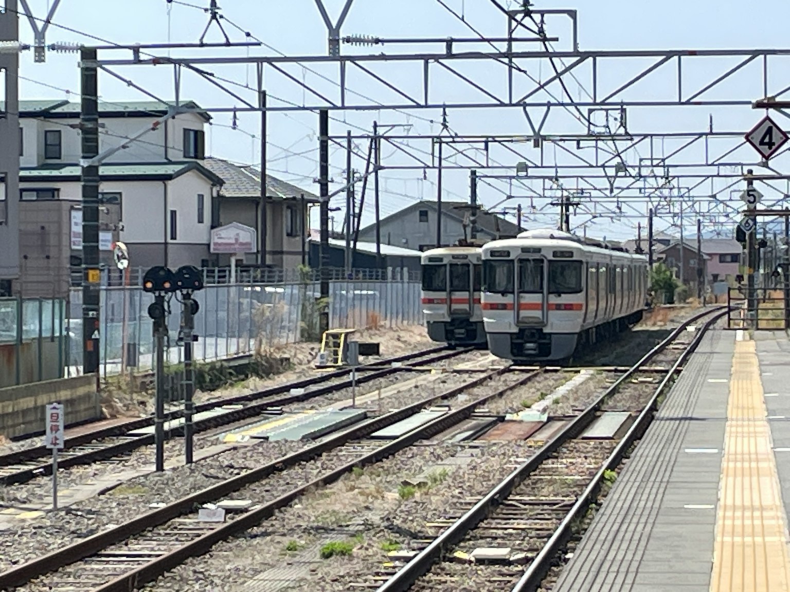 Train stopped at a station platform with visible tracks