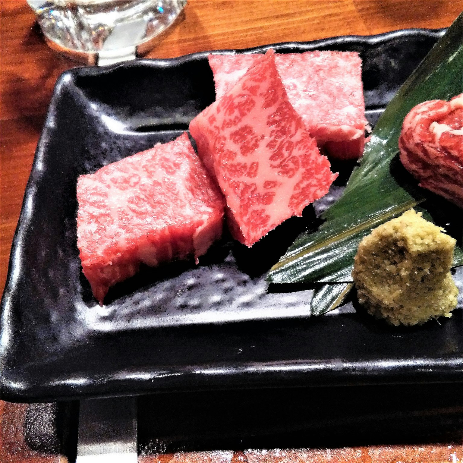 黑色盤子上盛放的和牛肉塊和芥末