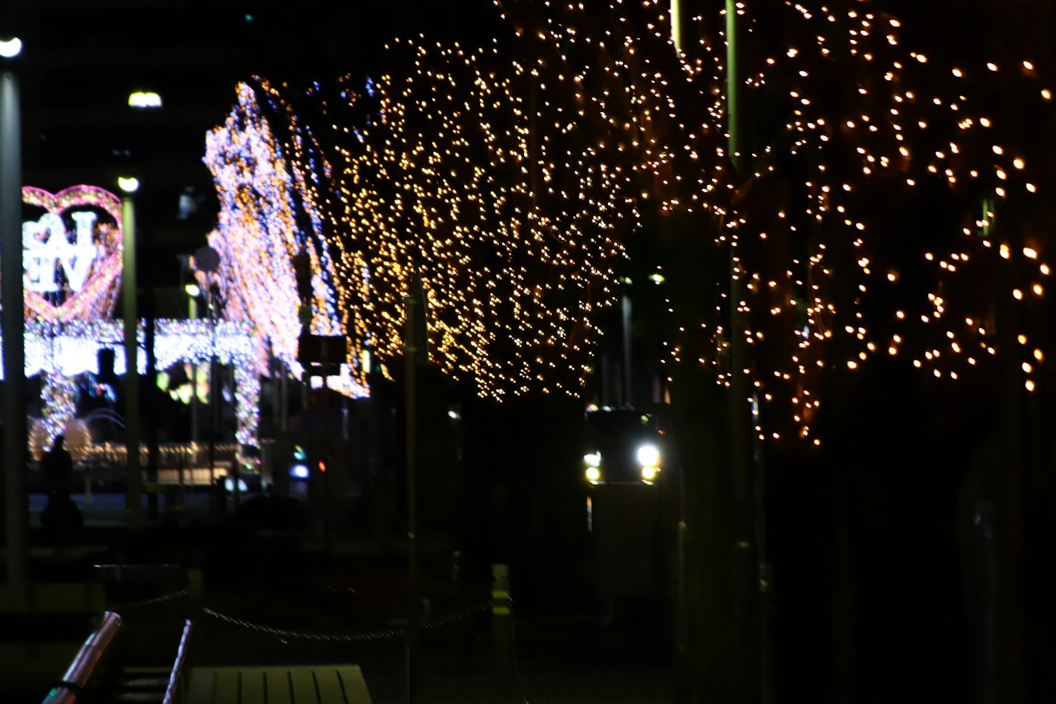 Strada della città decorata con alberi luminosi e luci festive