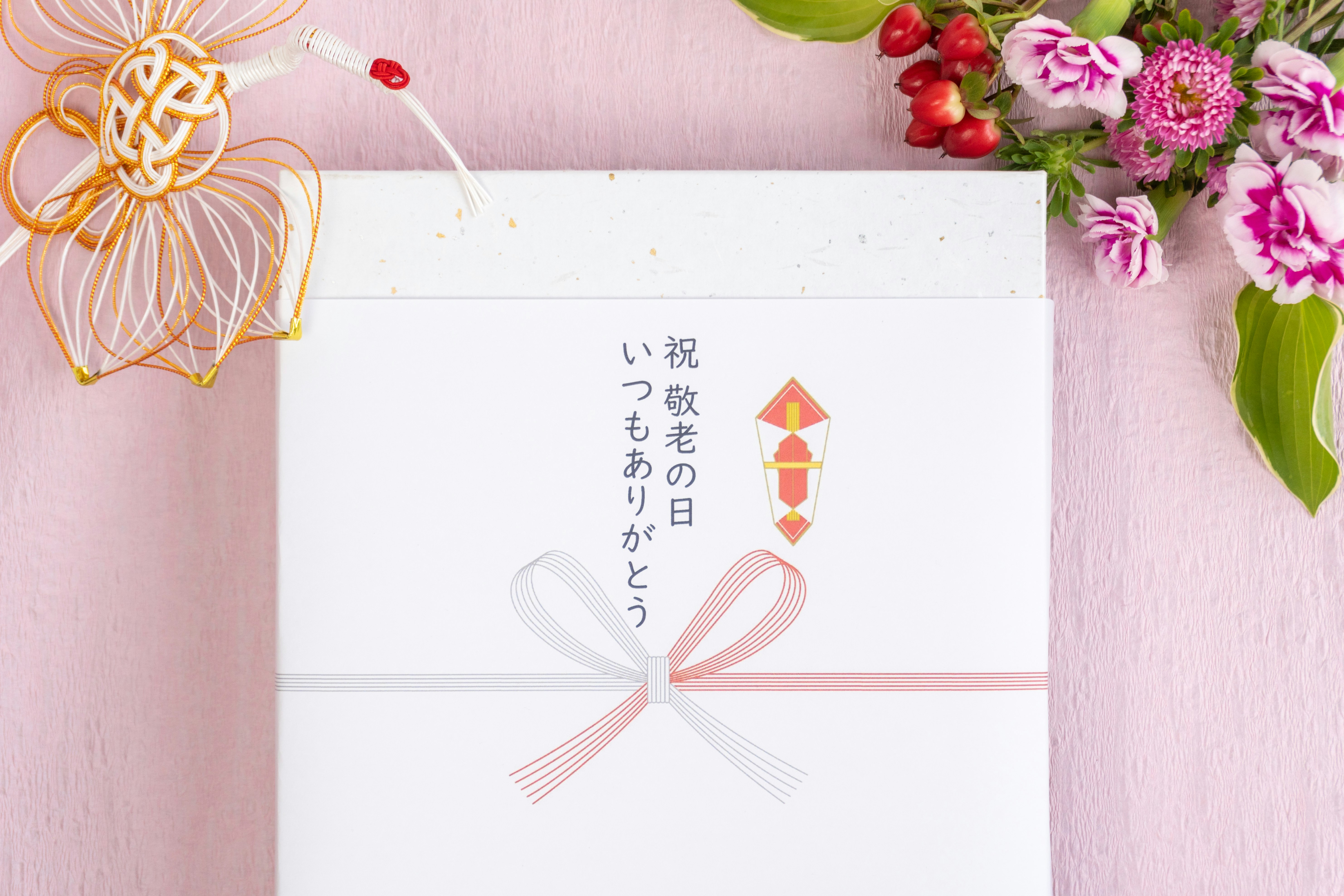 粉色花朵与日式祝贺贺卡的礼物俯视图