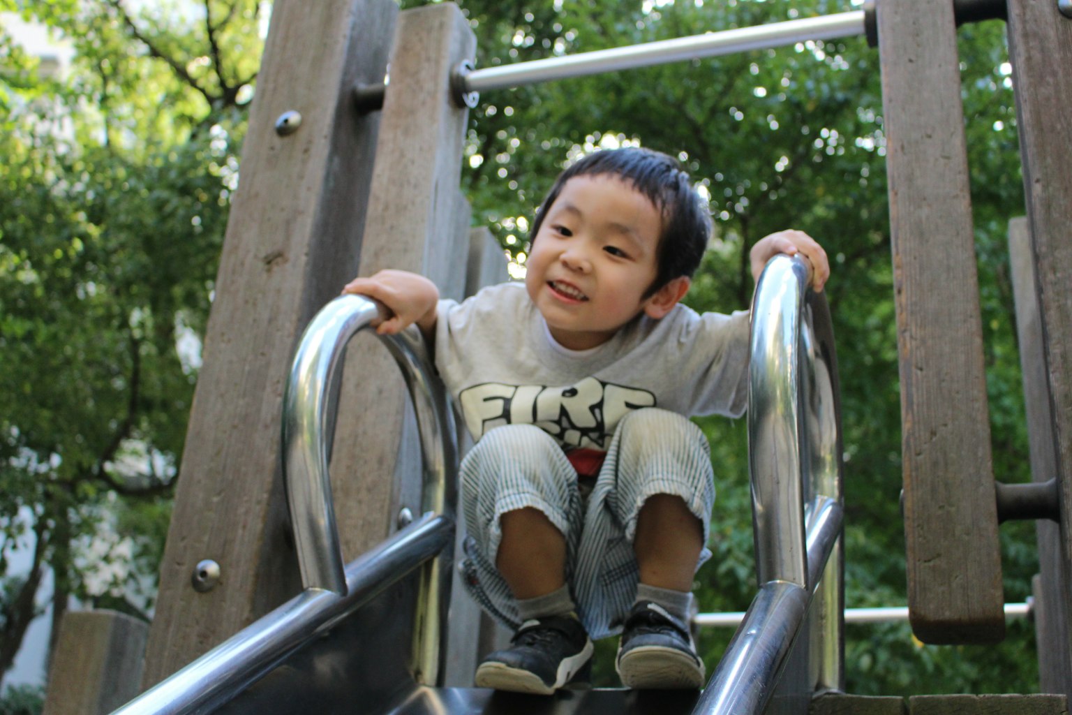 Niño sonriendo en un tobogán de parque