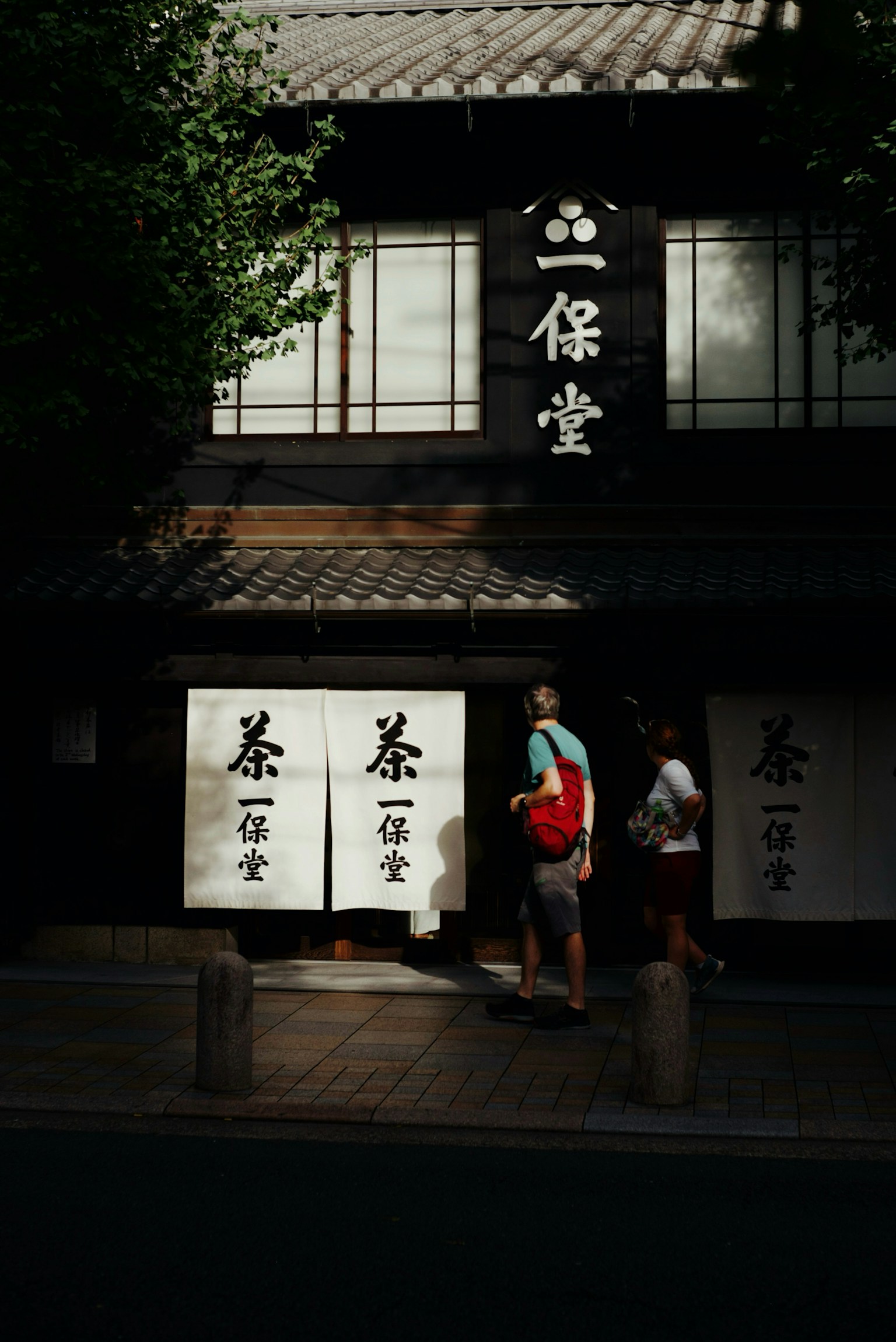 伝統的な日本の茶屋の外観と人々が通り過ぎる様子