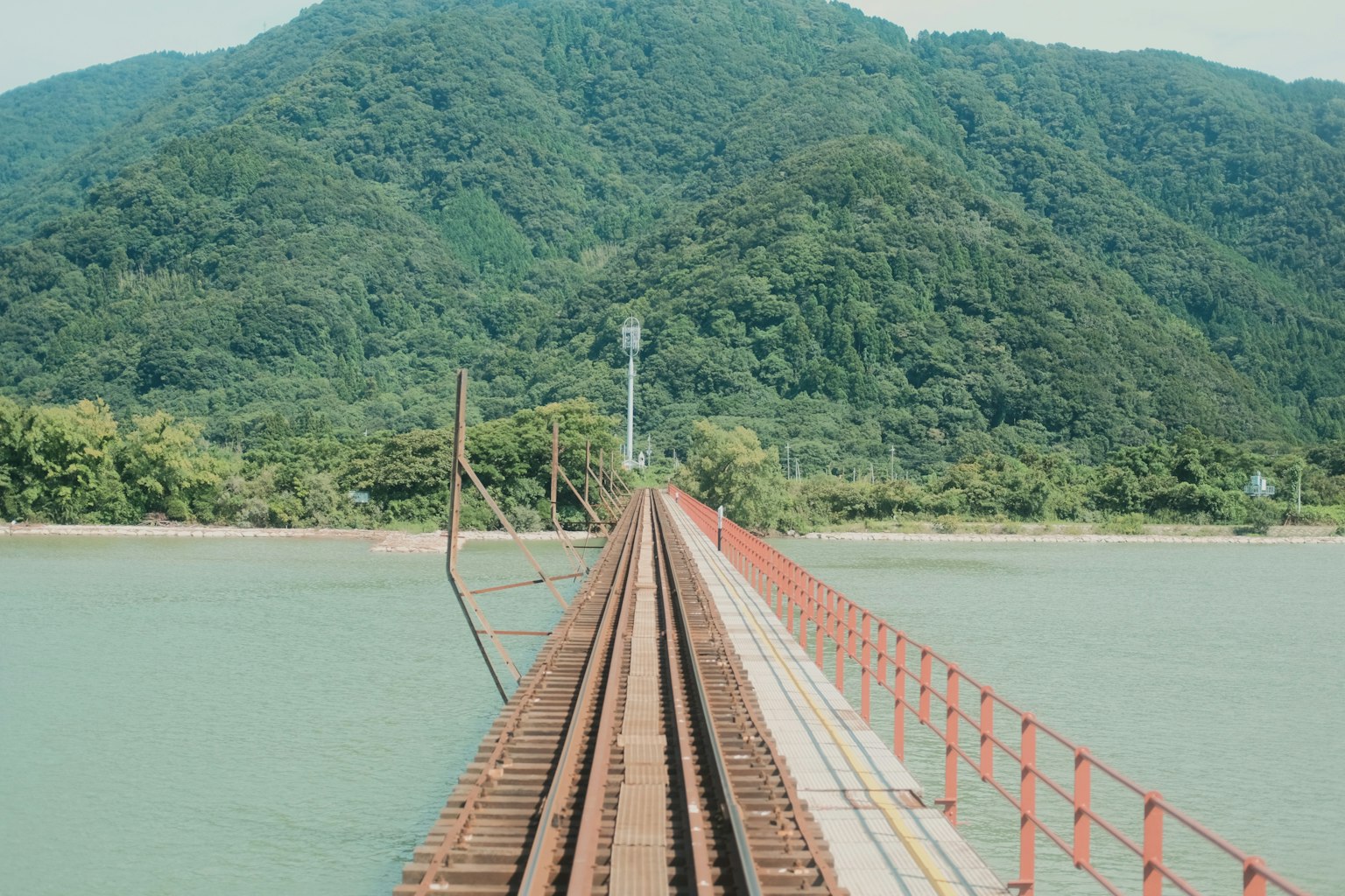 Puente que se extiende sobre el agua hacia una montaña
