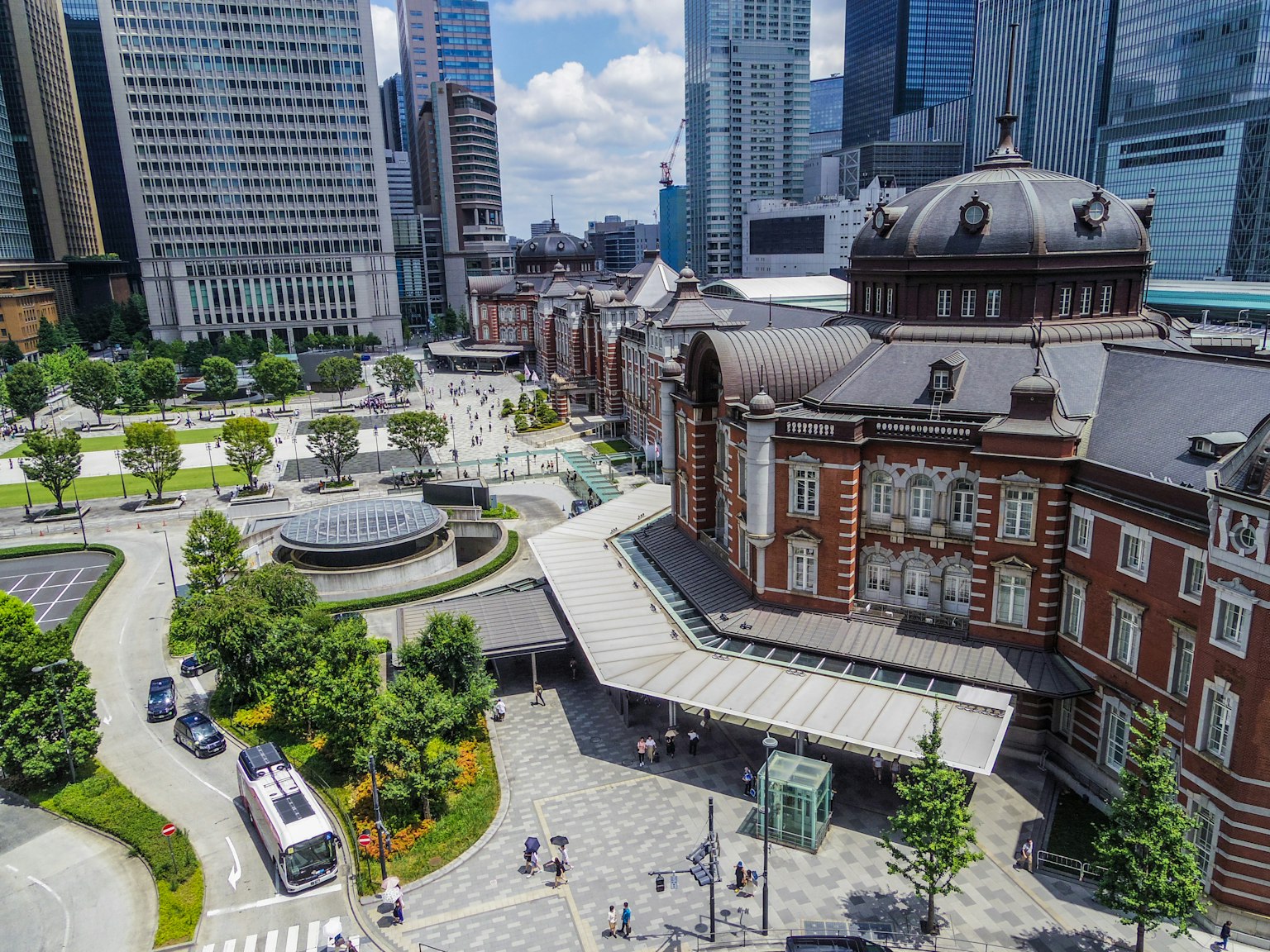 Vista del edificio histórico de la estación de Tokio rodeado de rascacielos modernos