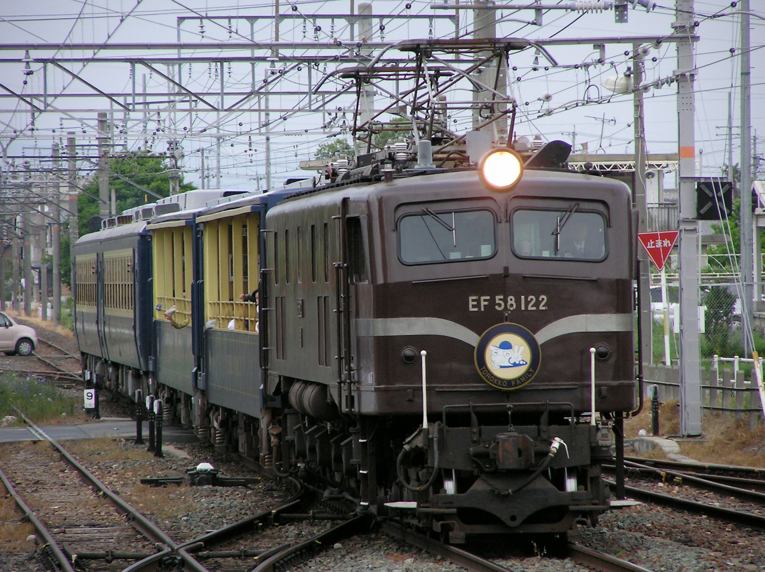 갈색 EF58122 기관차가 노란 객차를 끌고 있는 철도 장면
