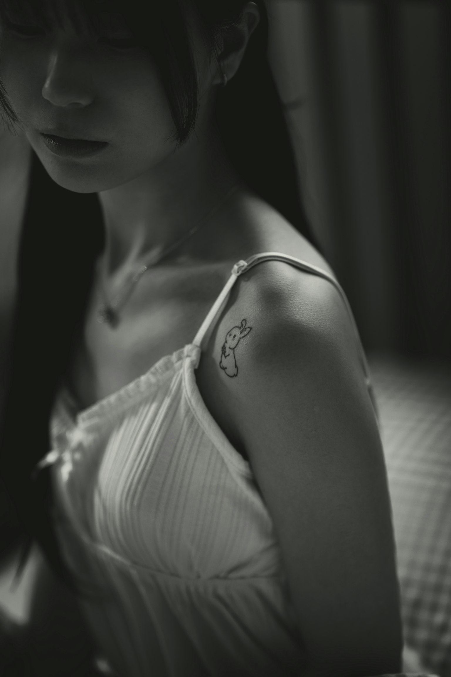 Black and white portrait of a woman with a tattoo on her shoulder