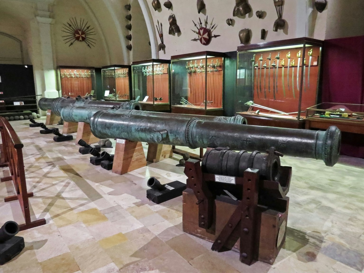 Un cannone esposto e una collezione di armi in un museo