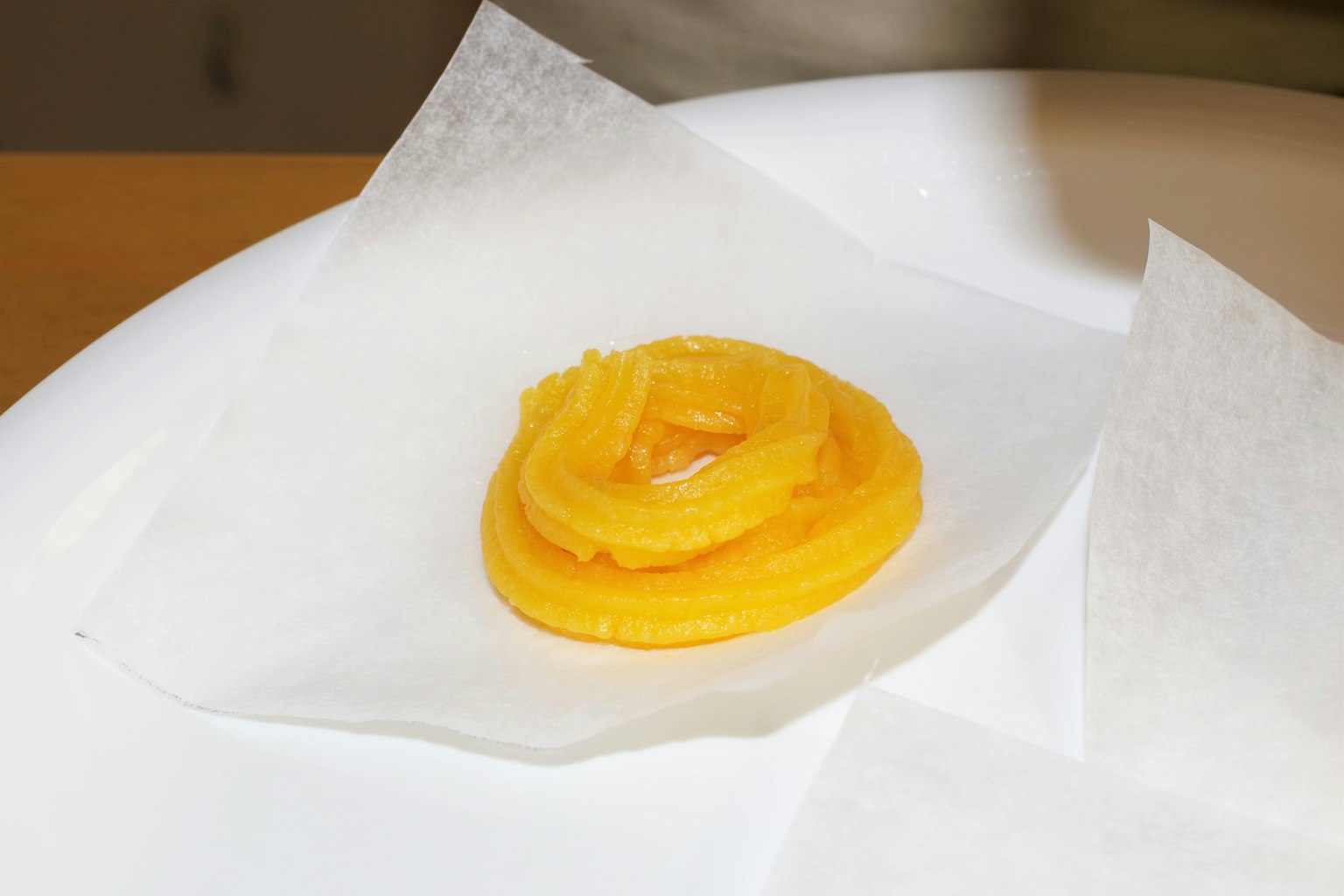 Gelbes Dessert auf einem weißen Teller