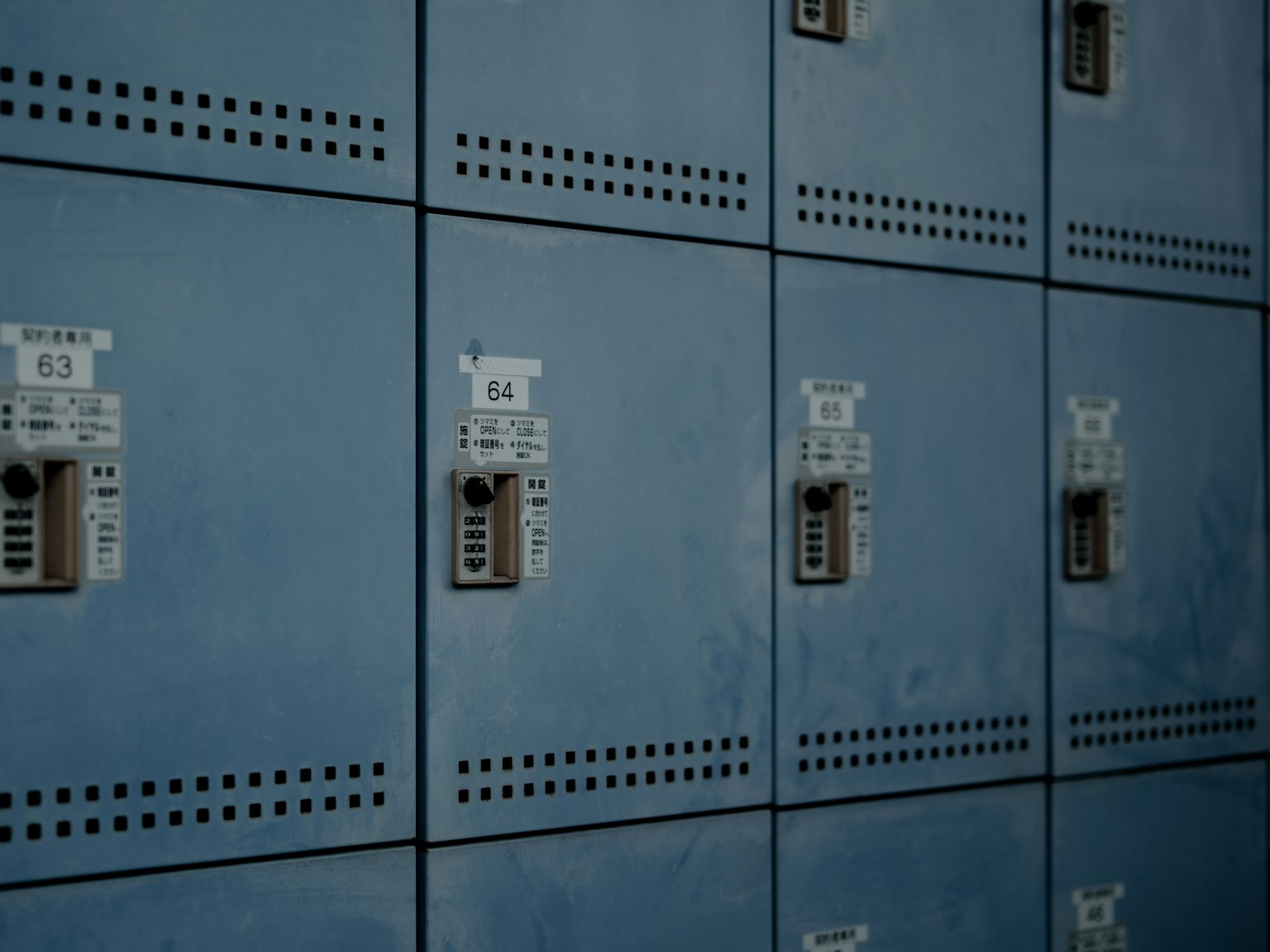 Close-up of a row of blue lockers featuring combination locks