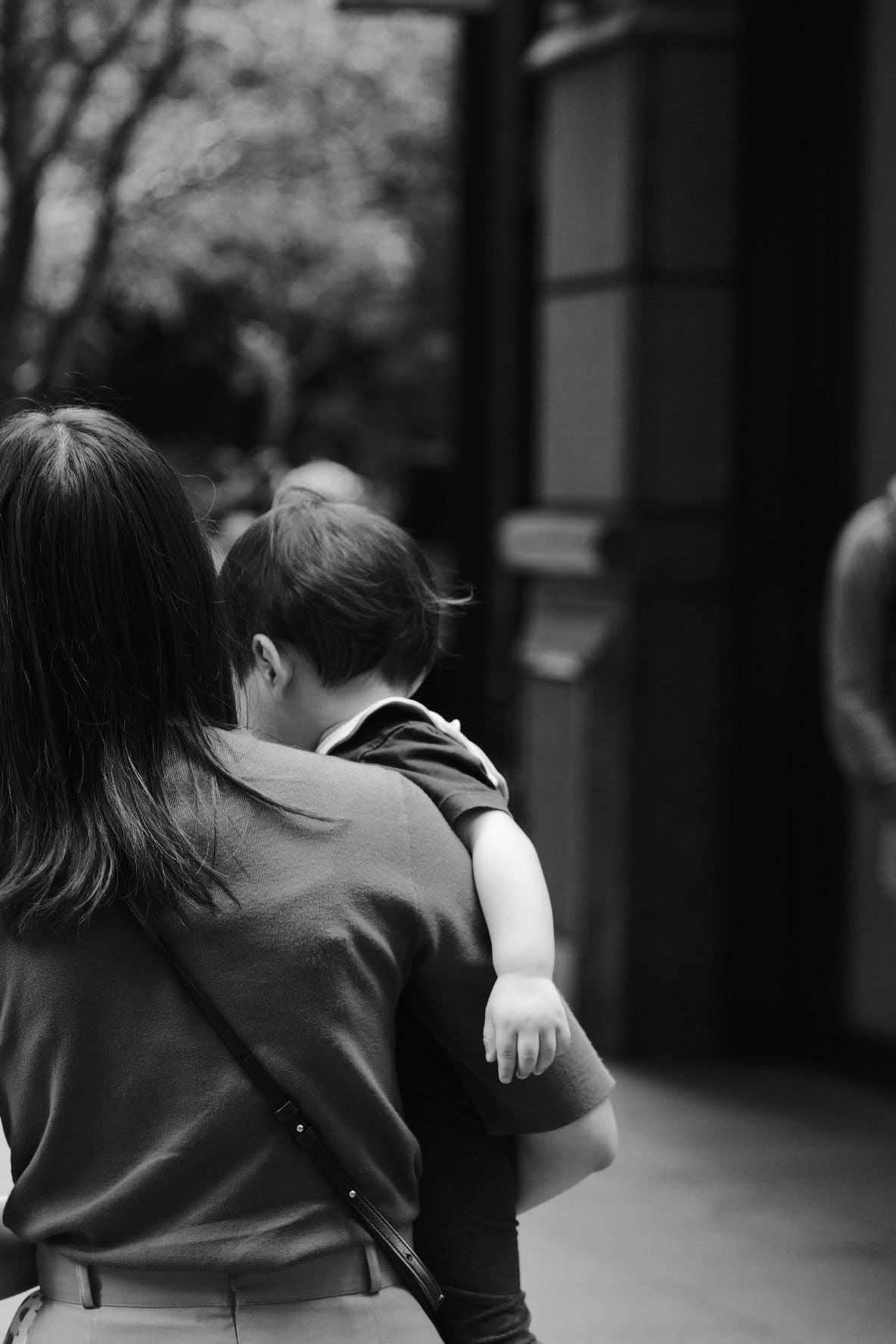 Black and white photo of a mother carrying her child