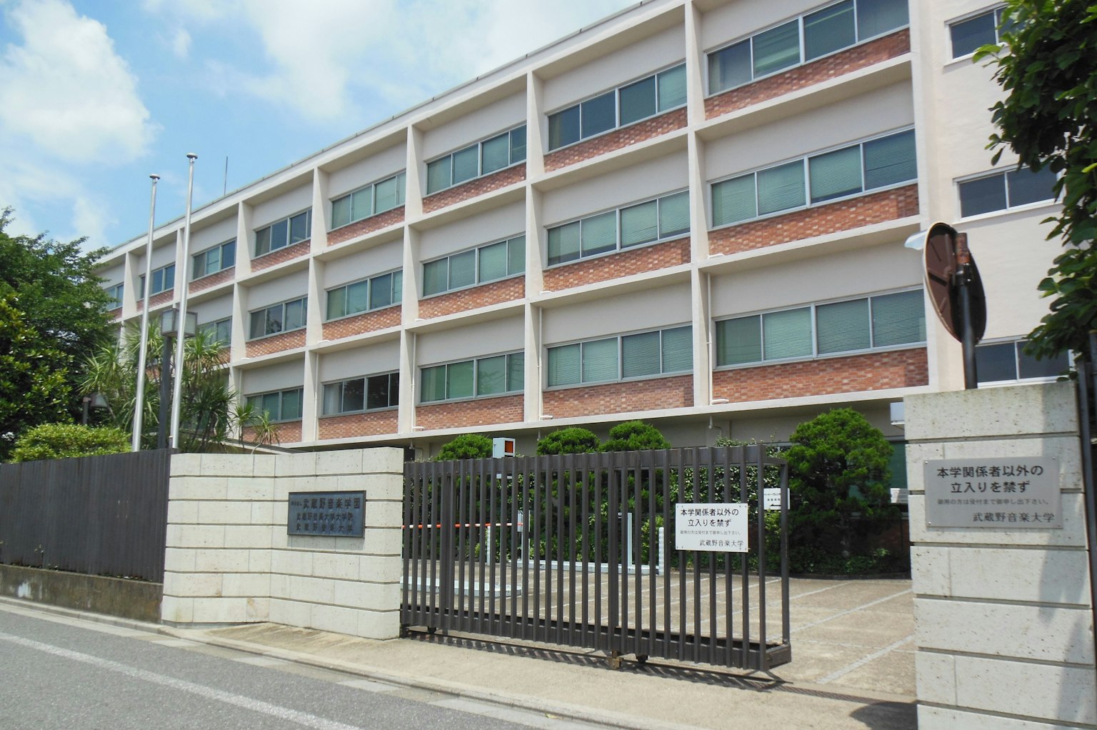 Bâtiment scolaire à l'extérieur blanc et ciel bleu entrée fermée avec verdure