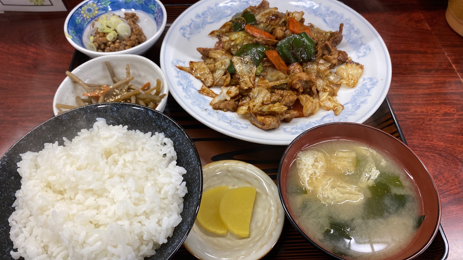 美味的日本定食，包括炒雞肉、白米飯、味噌湯、醃菜和配菜