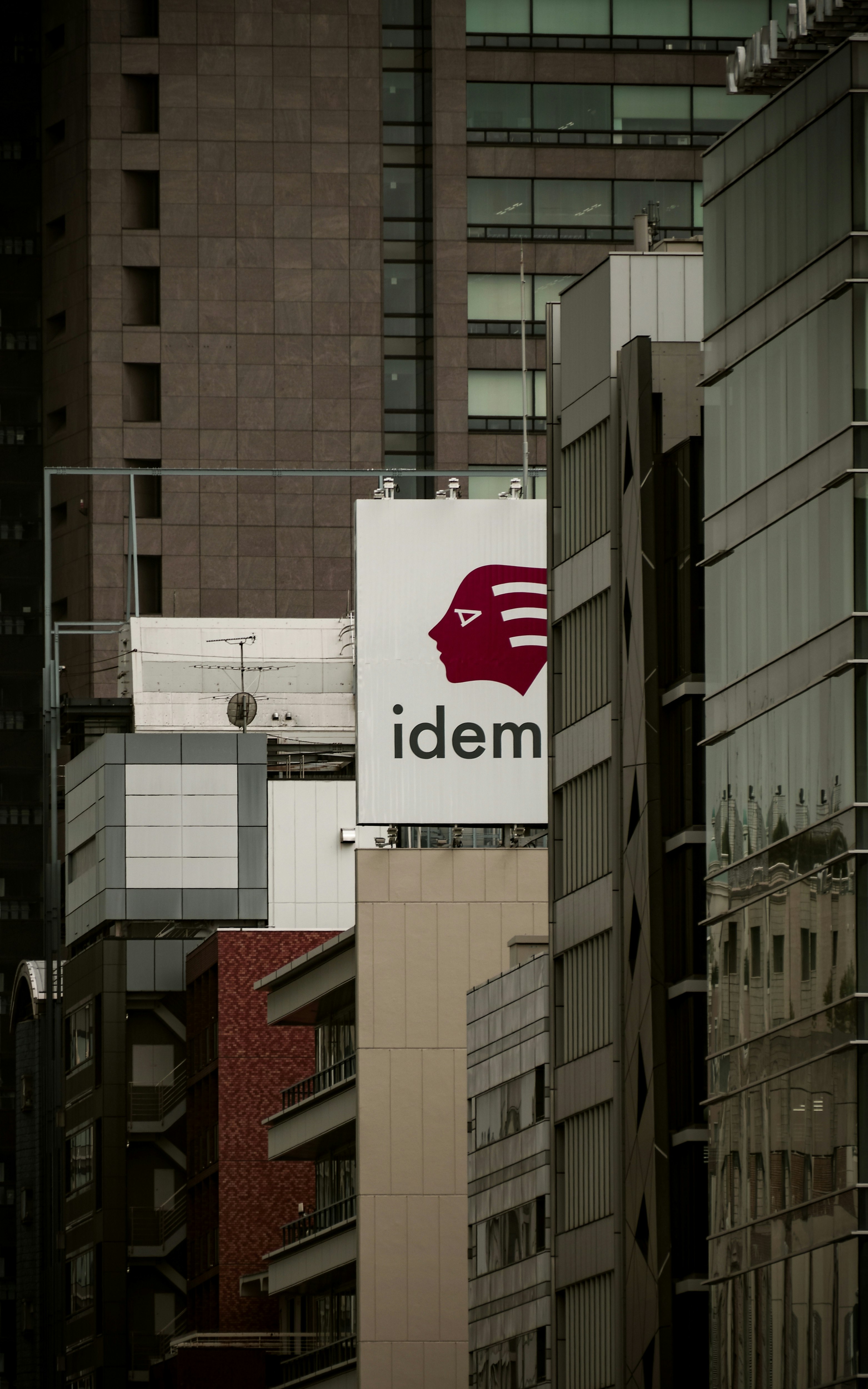 東京のビル街に掲げられた「idem」看板のある建物の外観