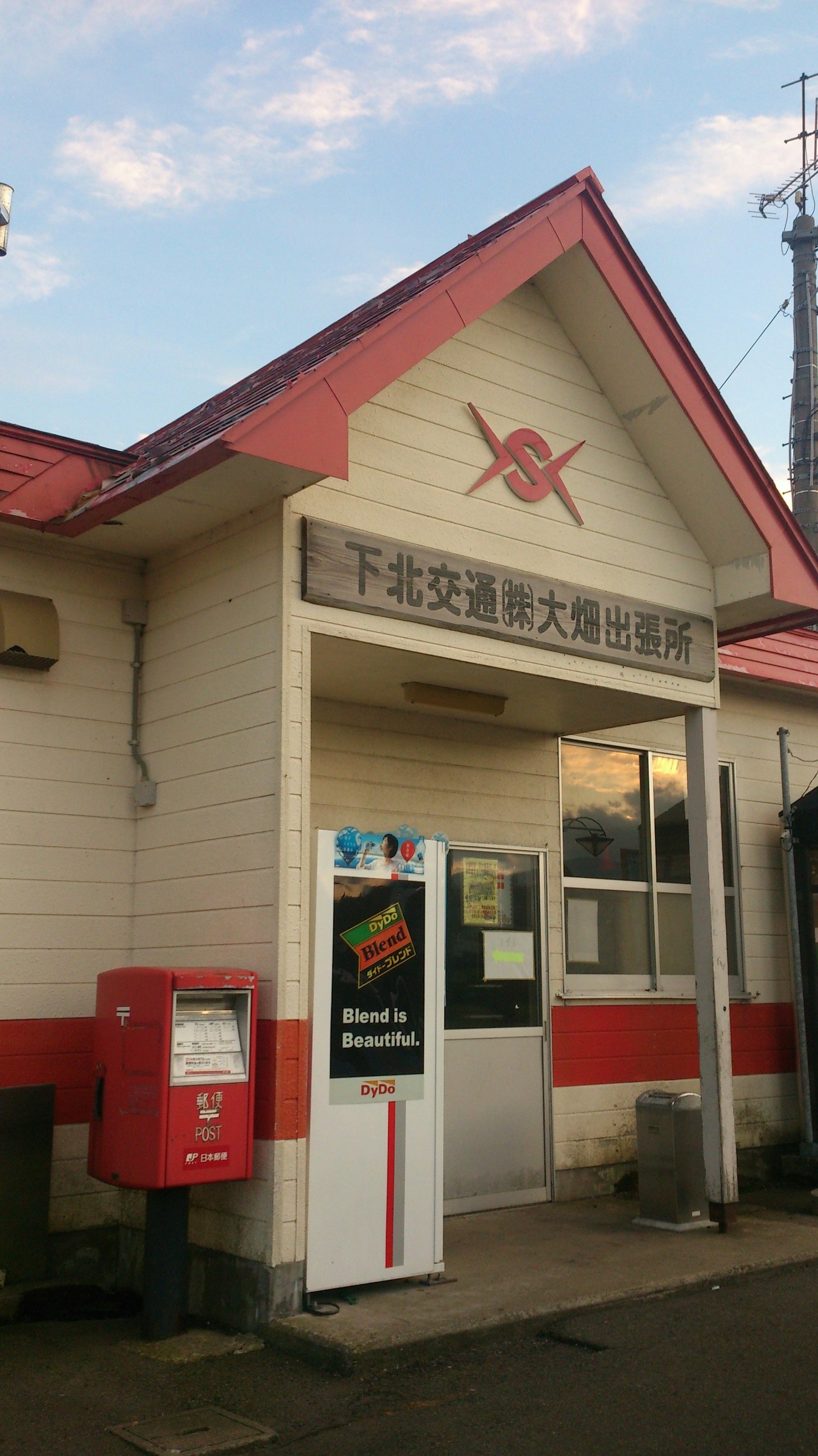 Small train station with a red roof and a mailbox