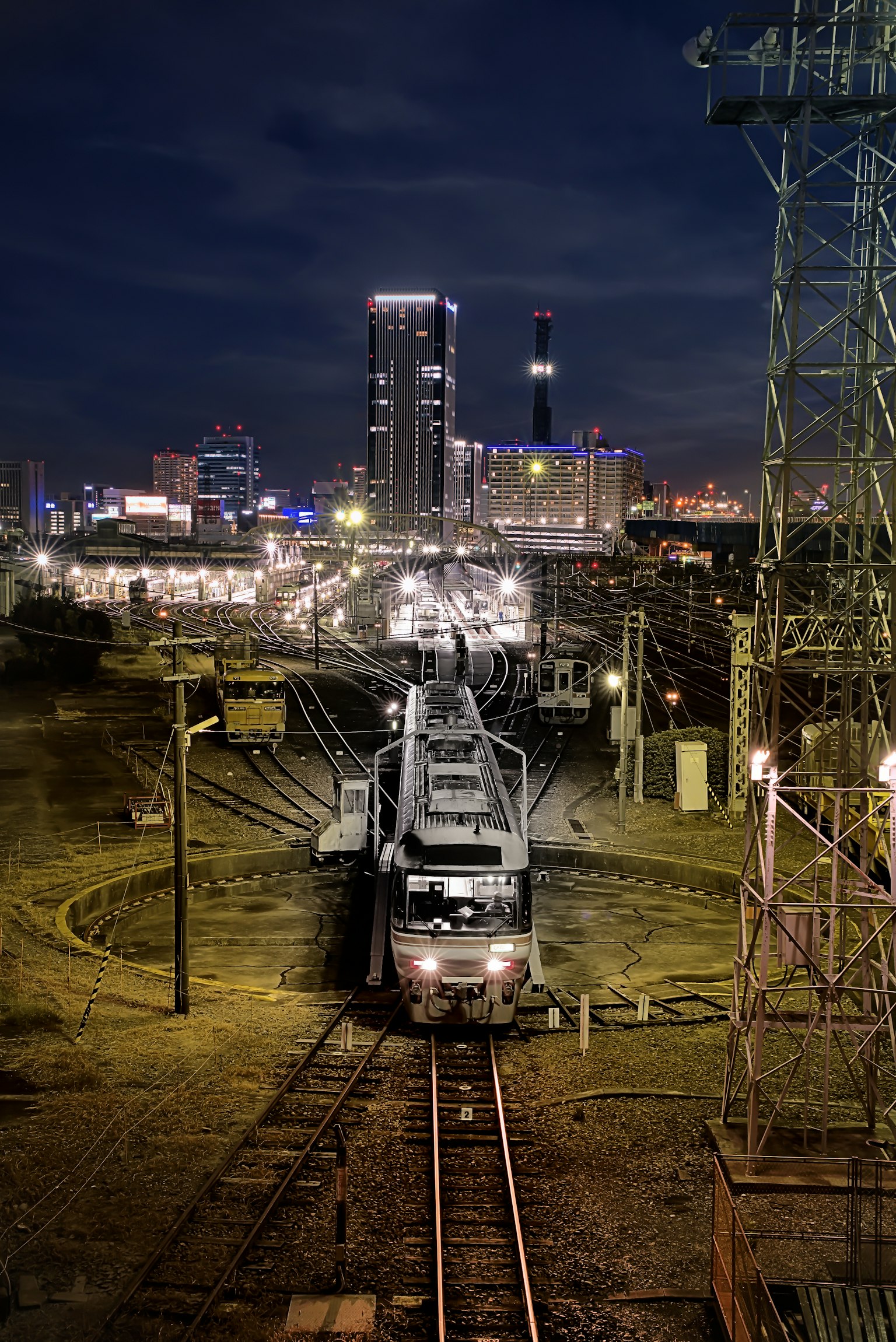 Locomotiva su una pista circolare con lo skyline della città di notte