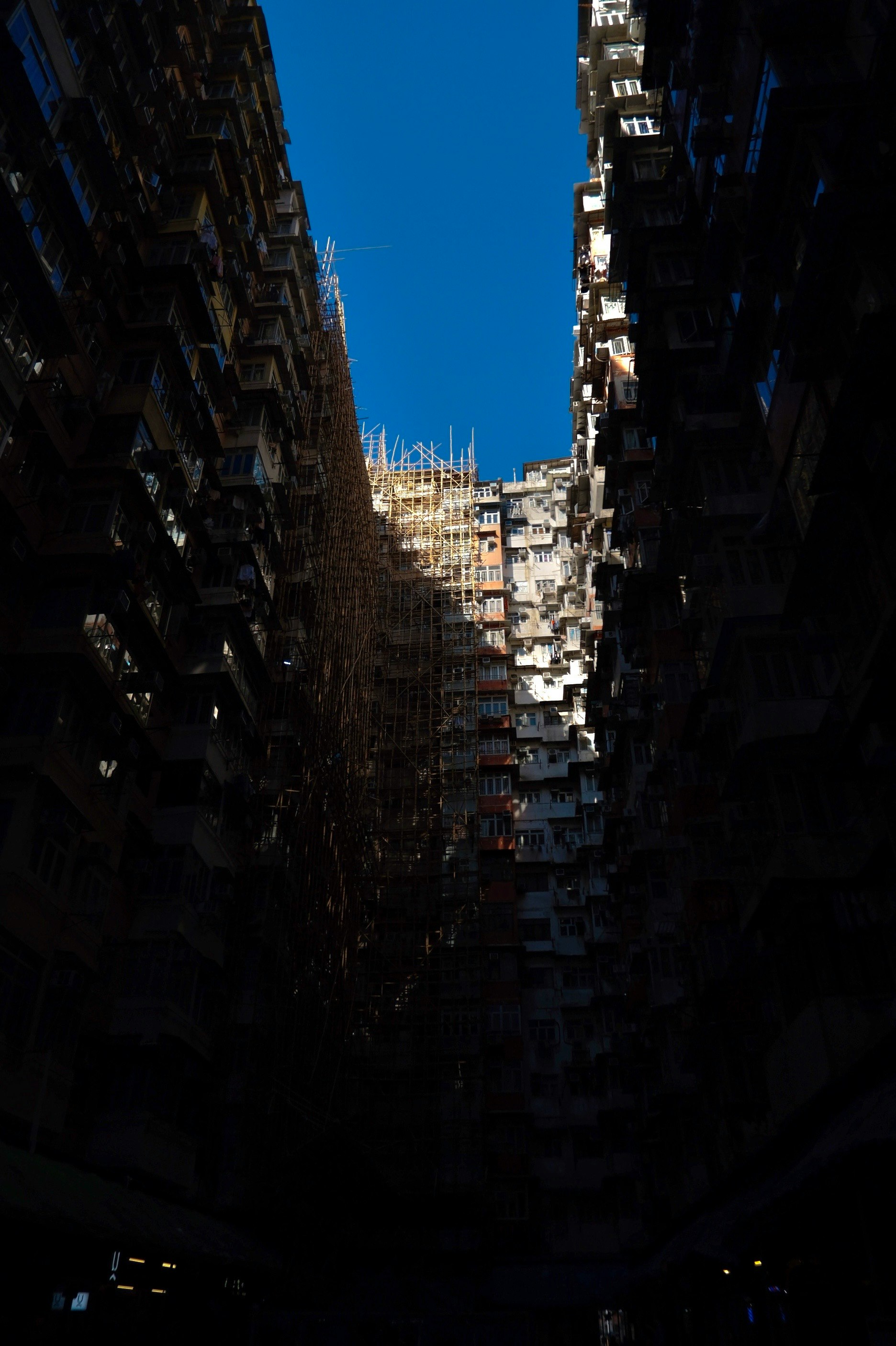 view down a narrow urban canyon between tall buildings