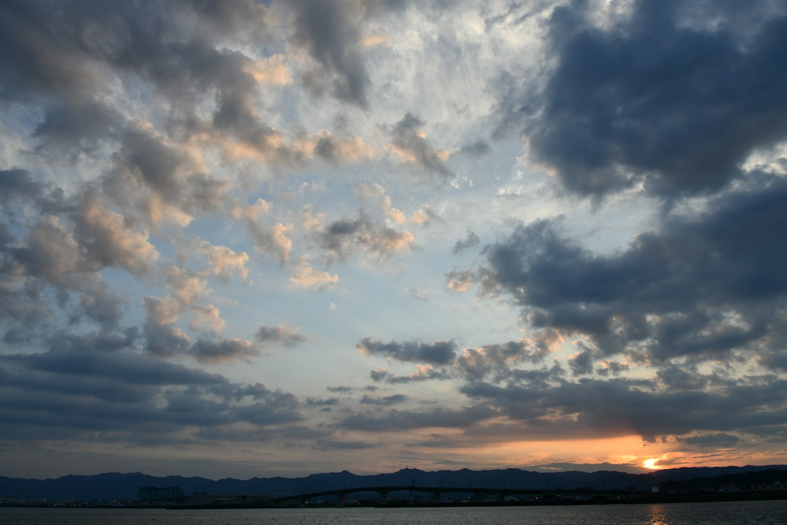 Cielo al tramonto con nuvole e montagne lontane