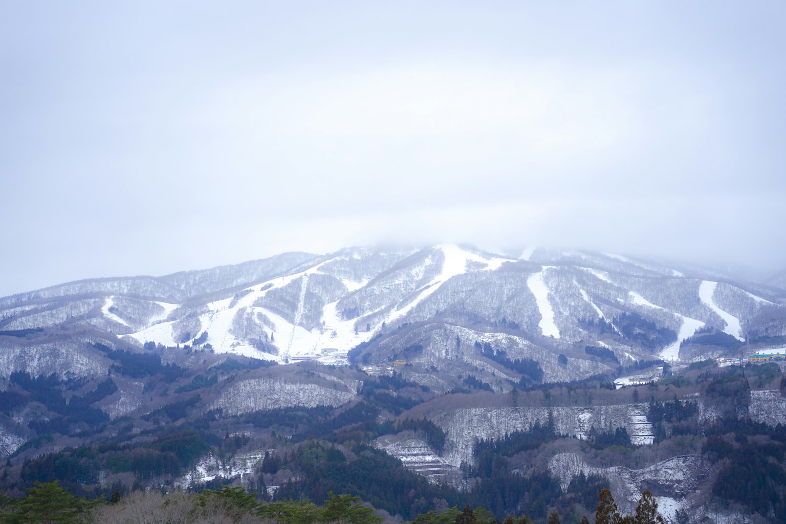 Schneebedeckte Bergkette unter einem bewölkten Himmel