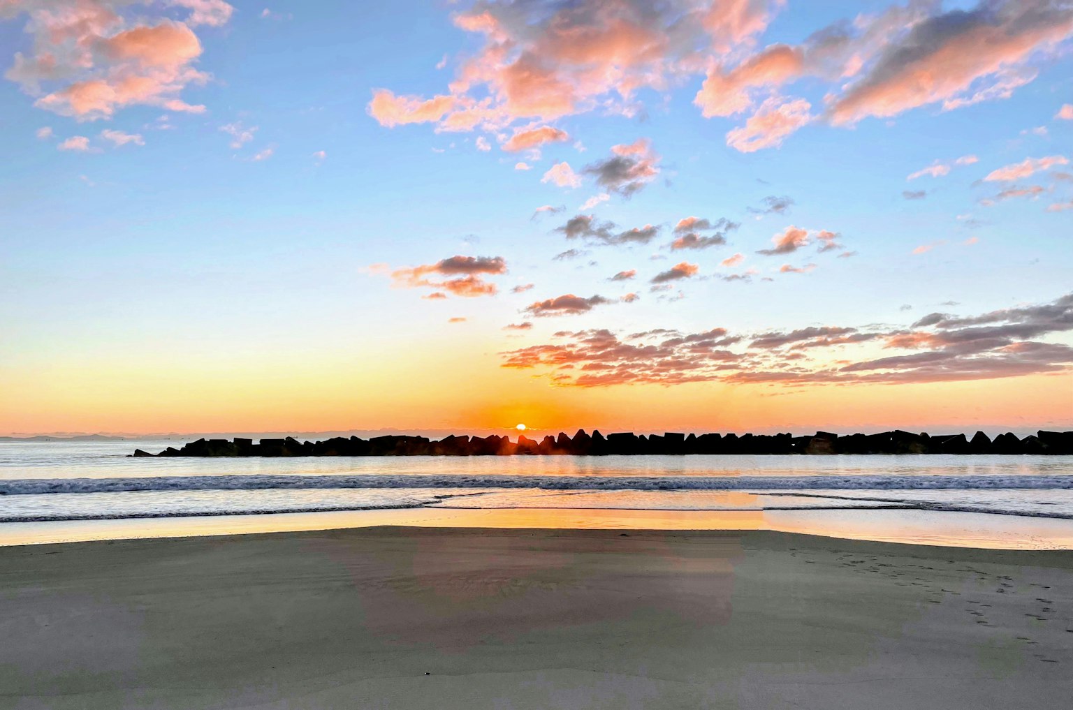Scenic view of a beach at sunset with colorful clouds