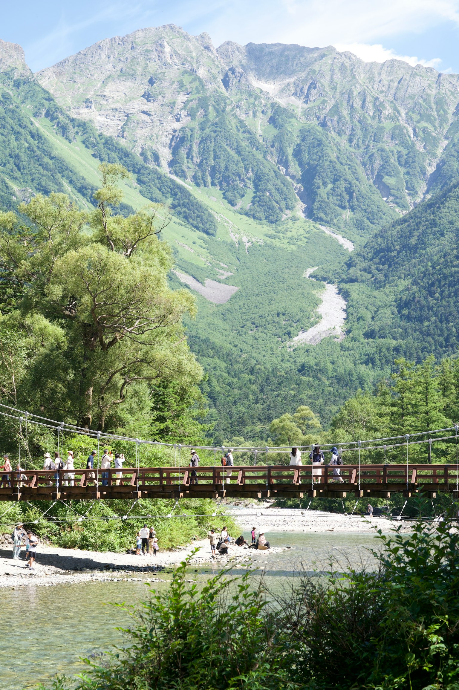 Scenic view featuring a wooden suspension bridge and majestic mountains