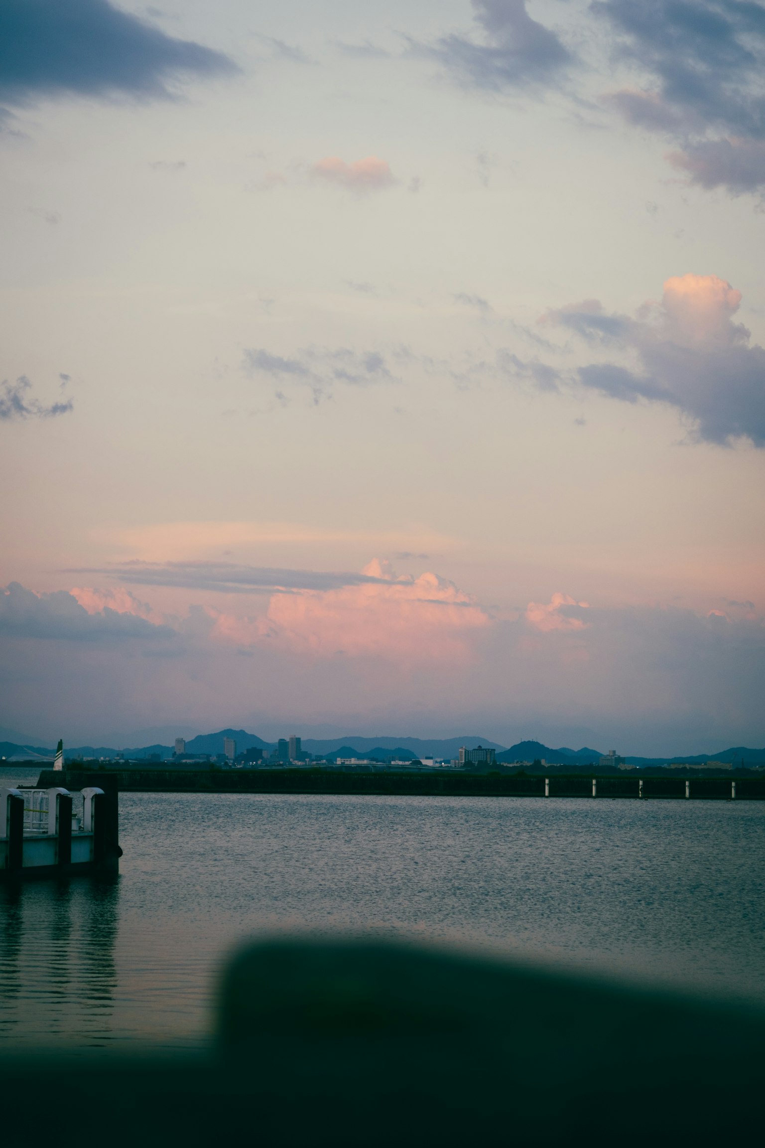 穏やかな水面に映る夕焼けの空と遠くの山々
