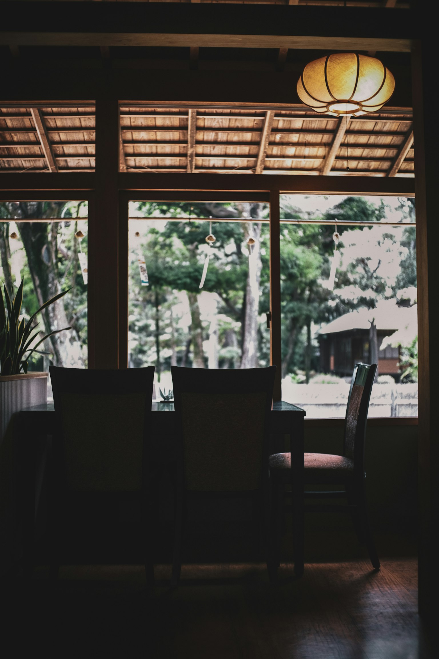 나무 테이블과 의자가 있는 고요한 방의 창을 통한 전망