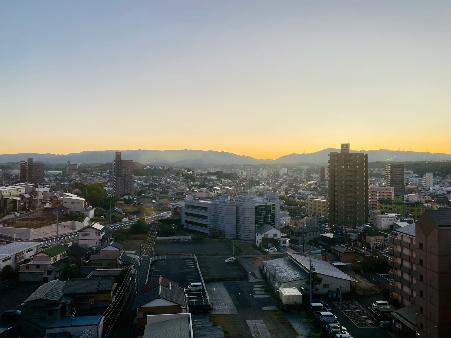 Vista panorámica de una ciudad al atardecer con edificios altos y áreas residenciales